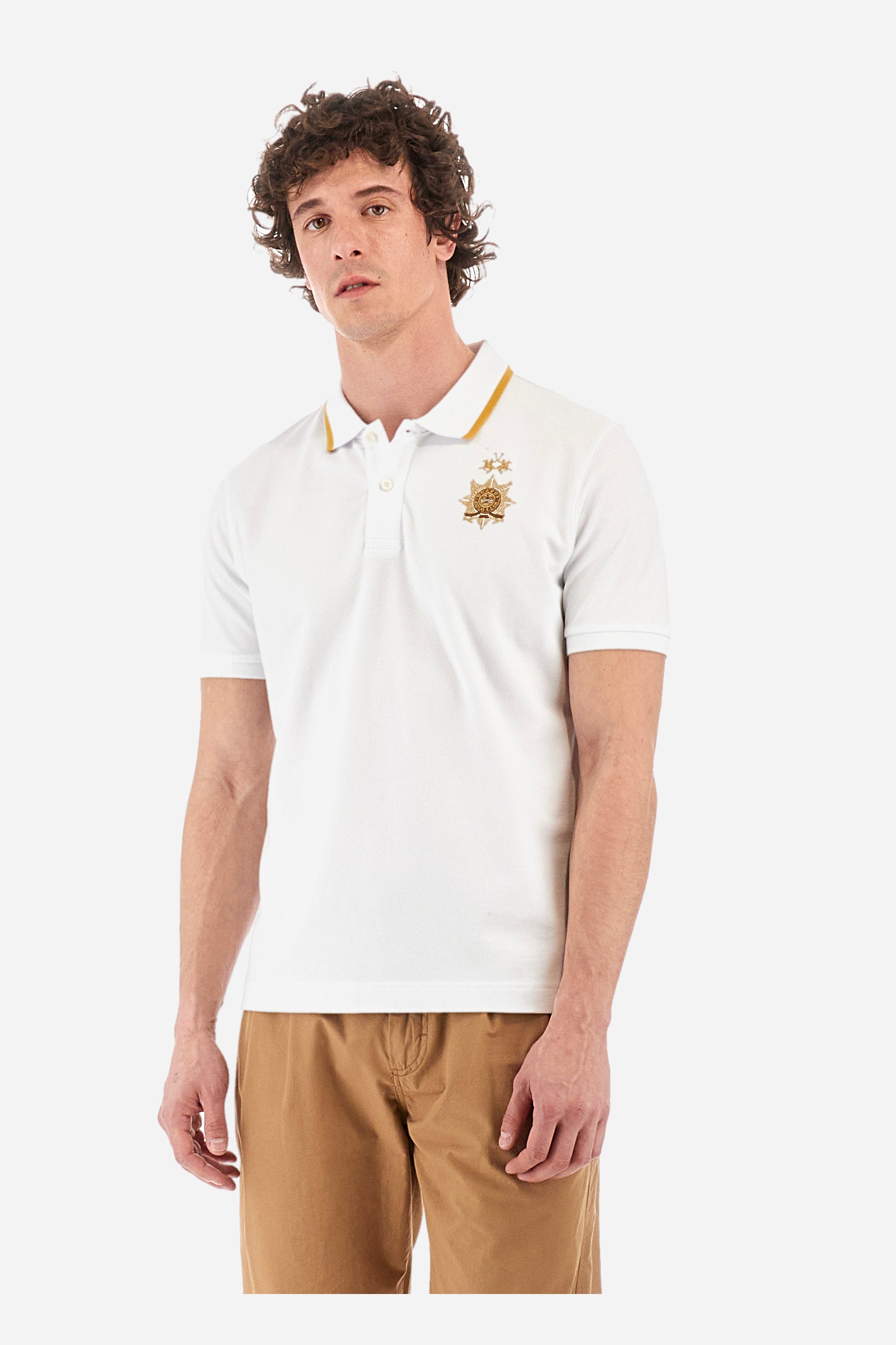 Men's short-sleeved single-colour polo shirt in elasticated cotton. Two-button fastening. Ribbed collar and armholes. The neck is profiled. On the front we find the symbol representing the Guards line. Featuring a small logo embroidered on the chest. The fit is regular. The model wears a size L. - Optic White