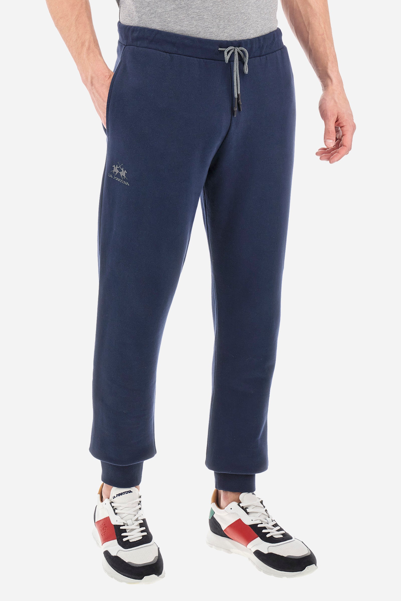 Men's jogging trousers with a logo print on the pocket in a regular fit. Features a drawstring waist, side pockets and back pocket. Made of 100% cotton with a regular fit, a must-have item in your wardrobe for the gym or leisure time. Very easy to combine with a sweatshirt or T-shirt. The model is 187 cm tall and wears a size L. - Navy