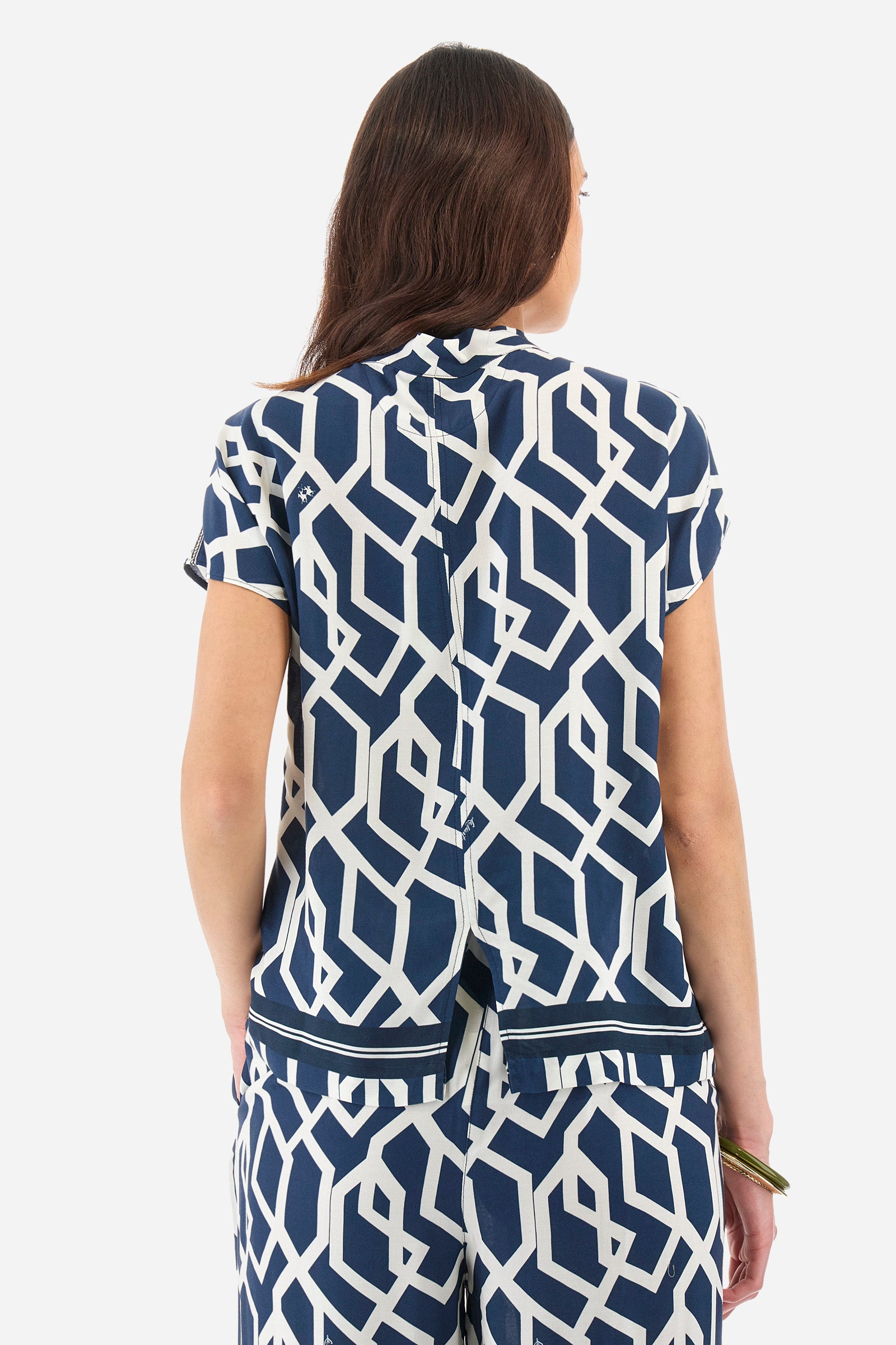 Women's short-sleeved blouse with a geometric print, made of synthetic fabric. A shawl collar. A small logo is present on a metal plate applied to the front and printed on the collar tie. The fit is regular. The model wears a size 2. - Orion blue/Off white