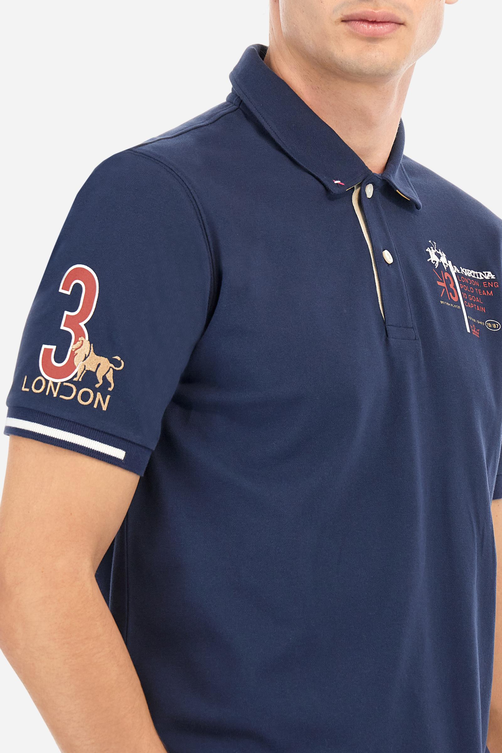 Short-sleeved, single-colour men's polo shirt made of stretch cotton piqué. Fastens with two buttons and internal opening, button side, in contrasting fabric. Ribbed collar and cuffs. The cuffs feature an inlaid detail in a contrasting colour. The graphics on the chest and back are made with mixed techniques: printing and embroidery. The logo is embroidered on the chest, left side. The fit is regular. The model is wearing a size L. - Navy