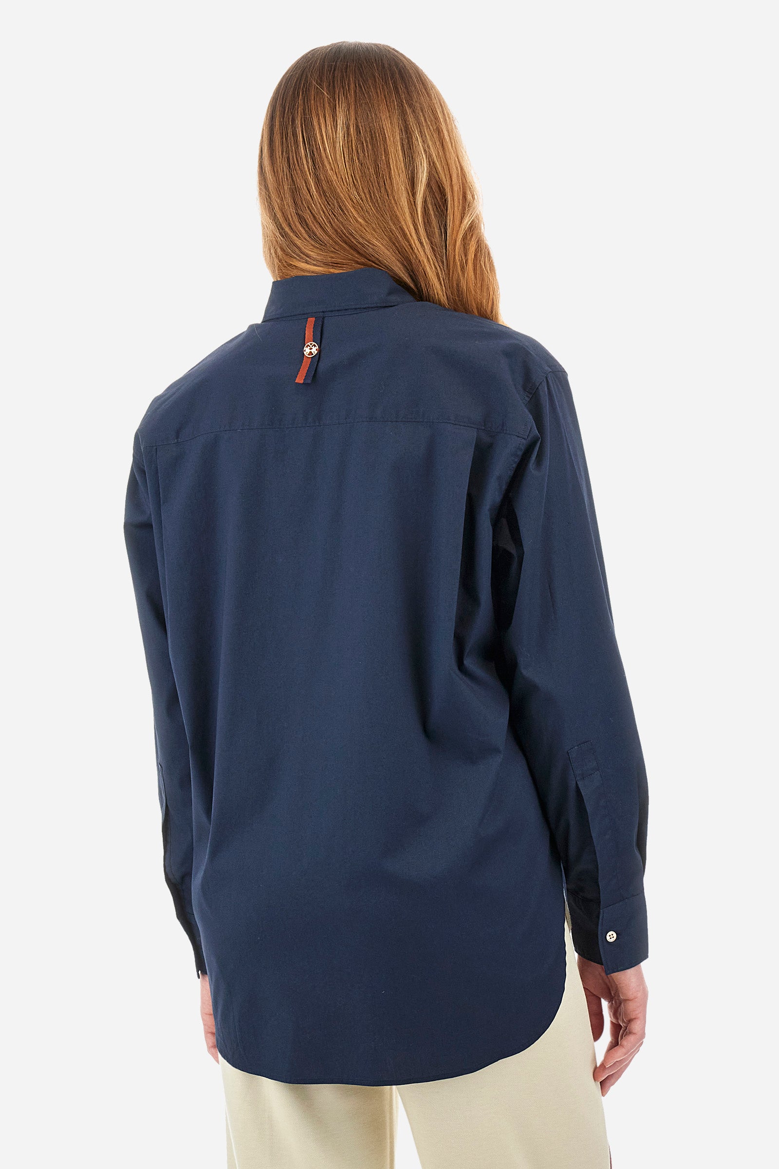 Women's long-sleeved patterned shirt in a single colour from the Polo Academy line. Made of stretch cotton. The internal part of the fastening features a touch of colour that contrasts with the main one. The logo and symbol of the Polo Academy line are sewn on the back. With buttoned cuffs. The logo is present on the back on a metal plate sewn onto a coloured strip. The fit is regular. The model wears a size 2. - Navy