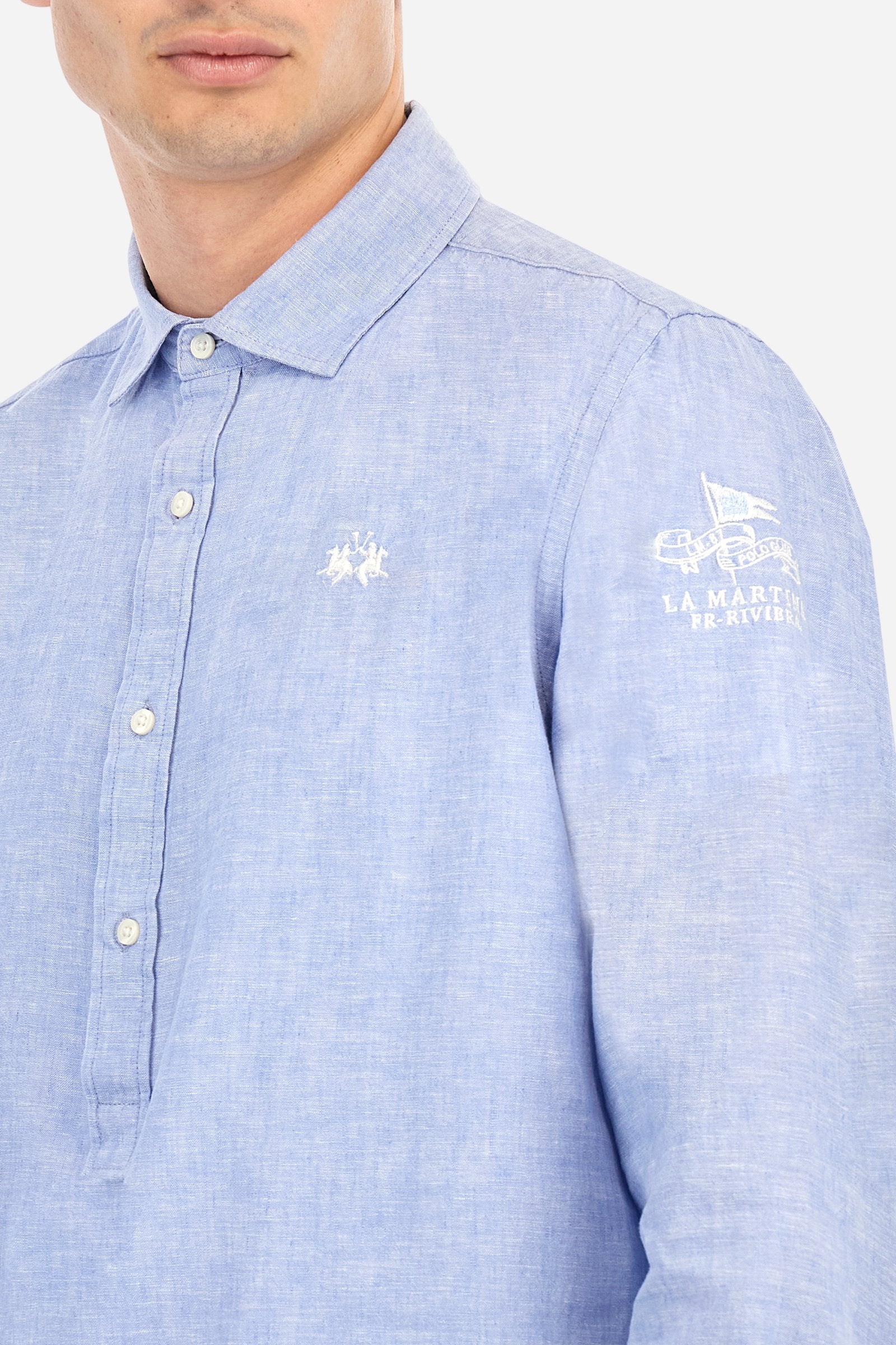 Men's plain long-sleeved shirt, made from luxurious cotton and linen canvas. The spread collar and the opening, which reaches the waist, are closed with 4 buttons. The left bicep is embellished with embroidered graphics depicting lettering, crests and numbers, created using contrasting thread. The logo is embroidered in contrasting thread on the left side of the chest. The regular fit offers a refined and comfortable look. The model is wearing a size L. - Cornflower blue