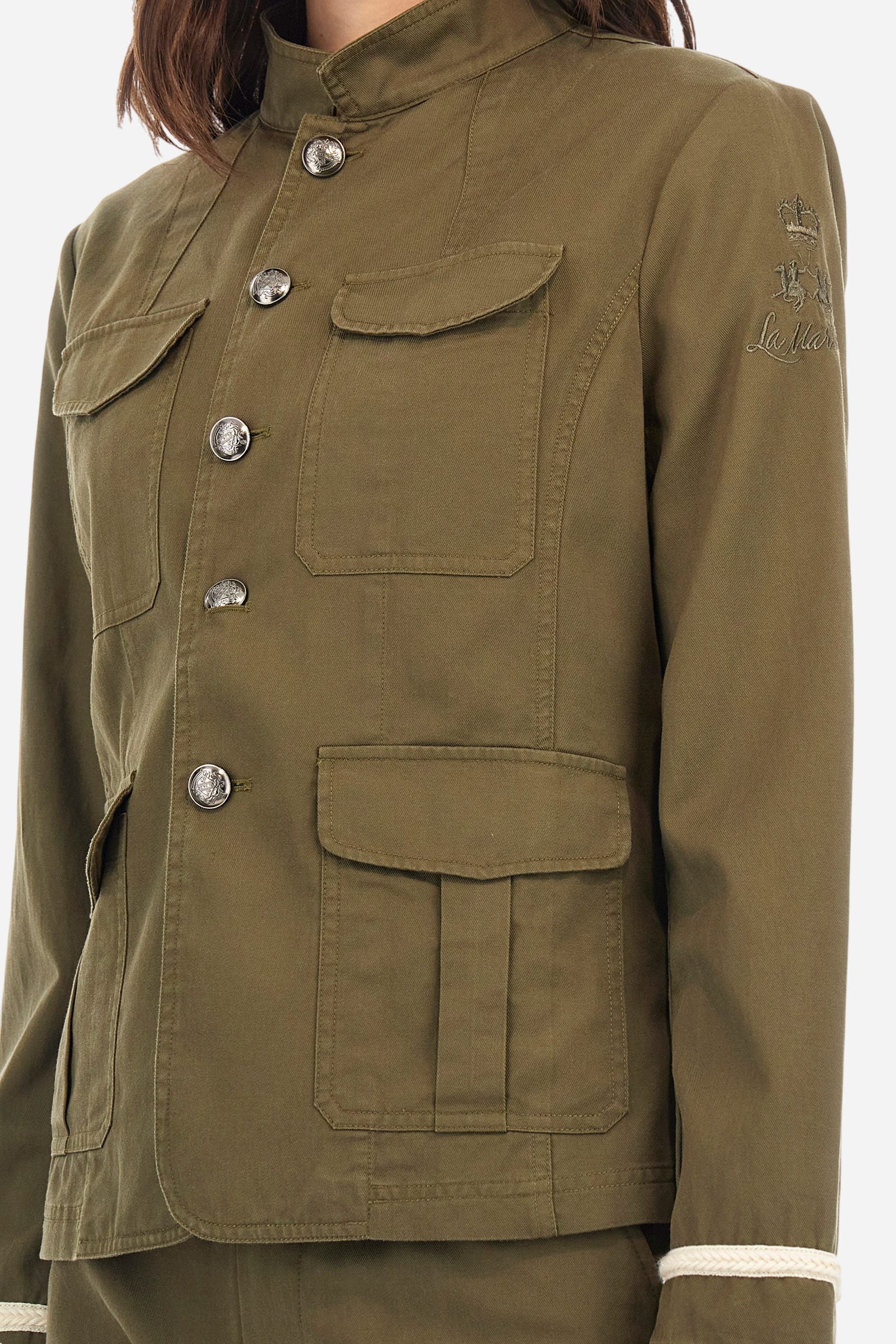 Women's long-sleeved safari jacket in a single colour, made of a cotton-modal blend drill.The front fastens with 5 metal buttons with heraldic motif. The front pockets are applied. Decorative braid-patterned trimmings are applied to the cuffs. The tone-in-tone logo graphic is embroidered on the left sleeve. Regular fit. The model is wearing a size 40. - Thyme