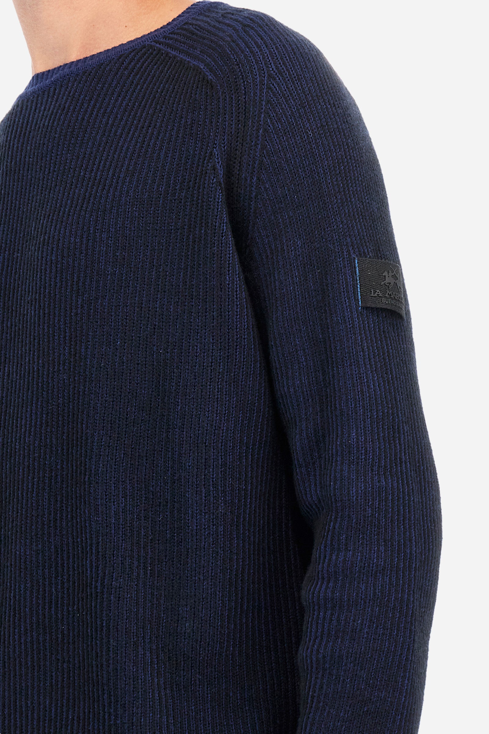 Men's long-sleeved crew neck pullover in plain ribbed fabric. Made from a blend of wool and cotton. The base colour of the garment contrasts against the ribs. A patch with the brand logo is sewn on one of the sleeves. Regular fit. The model is wearing a size L. - Navy/Black