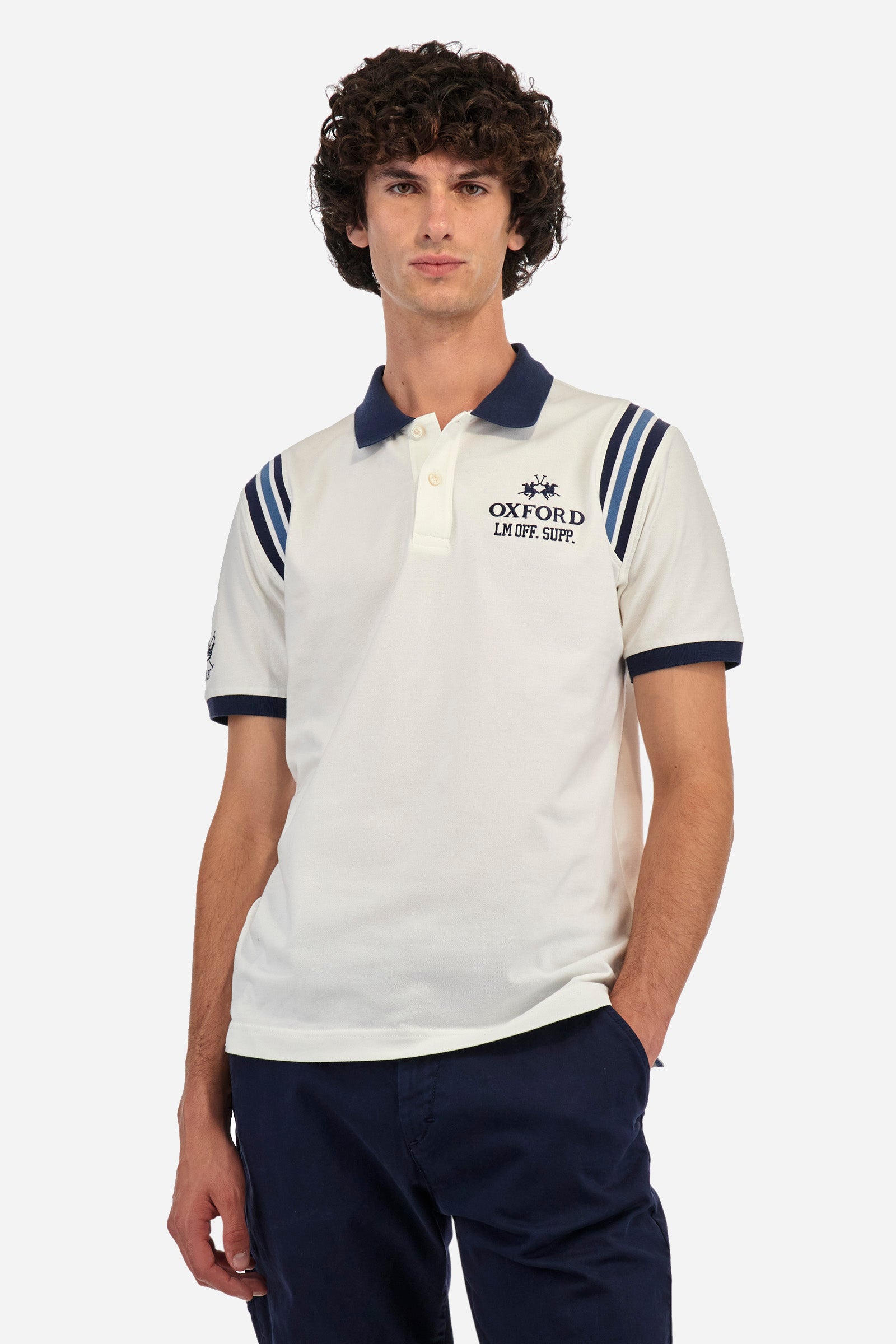 Men's short-sleeved polo shirt in plain stretch cotton. Two-button fastening. The sleeves are finished with contrasting stripes. The logo and lettering associated with the Oxford line are embroidered on the front. Regular fit. The model is wearing a size L. - Off White