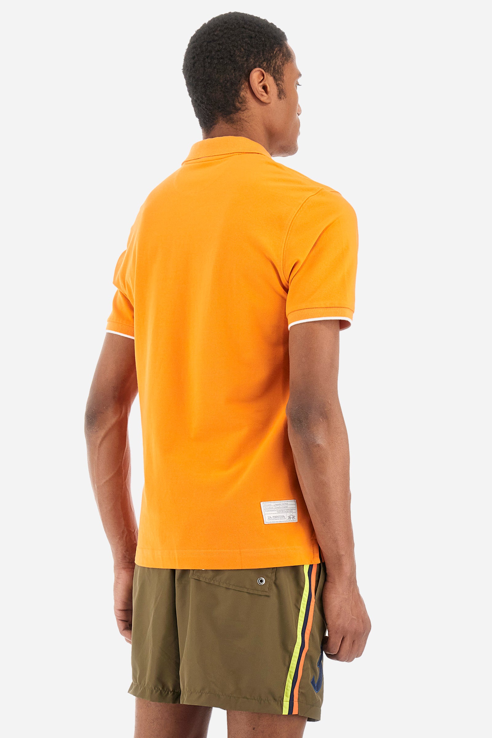 Men’s polo with short sleeves, regular fit. Made of stretch pique cotton. Classic model, with large embroidered logo in contrasting tone on the chest and profiled sleeve edges. The collar is accompanied by the writing La Martina, in contrasting tone. Ideal if worn with a denim collection. The model wears a size L. - Celosia Orange