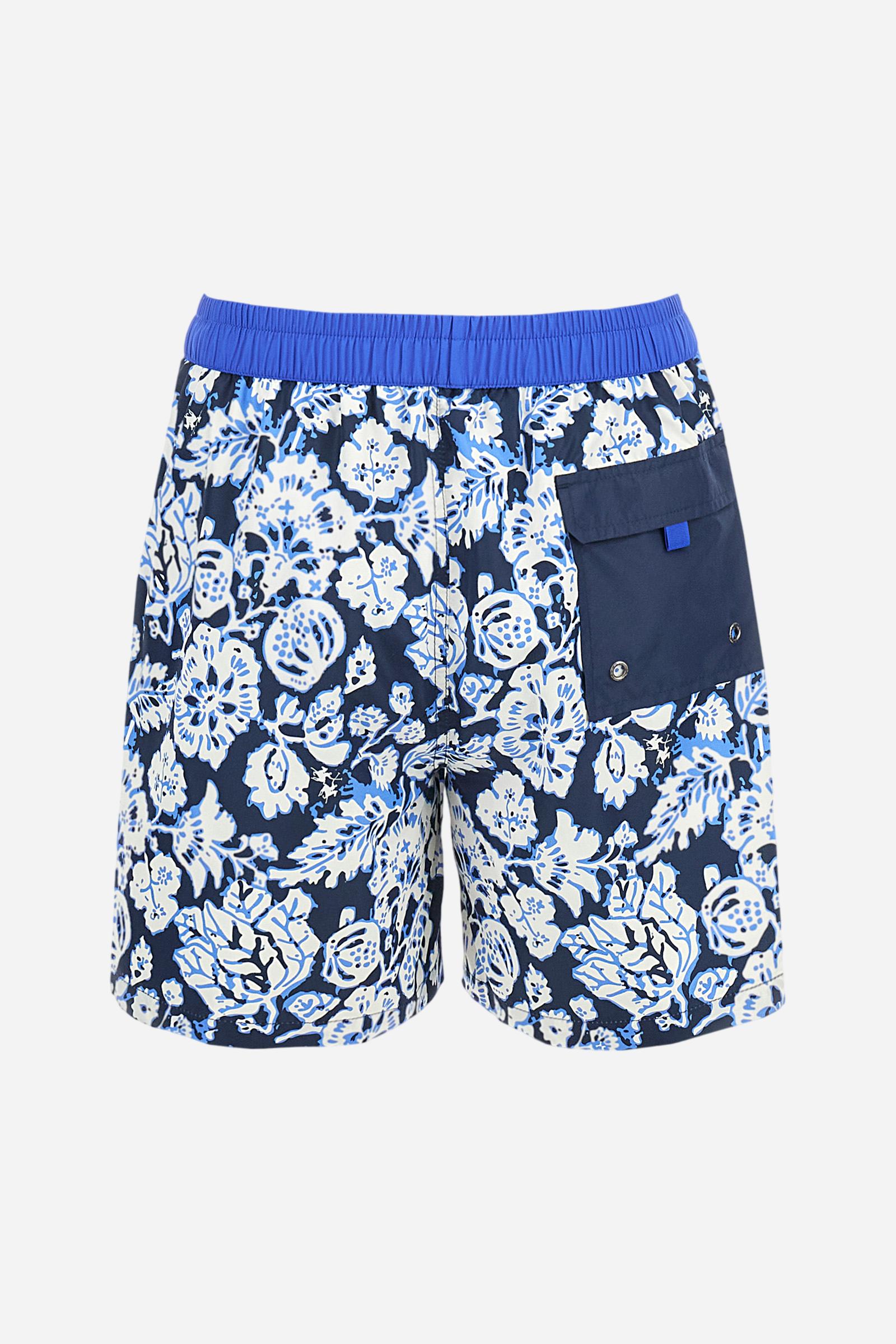 Men's swimming shorts, made of printed nylon. The stylised floral pattern is an exclusive design. The plain nylon elastic waistband has a custom drawstring inside for waist adjustment. On the inside of the shorts is an elasticated mesh brief. Featuring double side pockets on the hips and patch pocket with contrasting coloured flap on the back. The large logo is embroidered on the bottom of the left leg, on the front. Regular fit. The model is wearing a size L. - Navy/Dazzling Blue