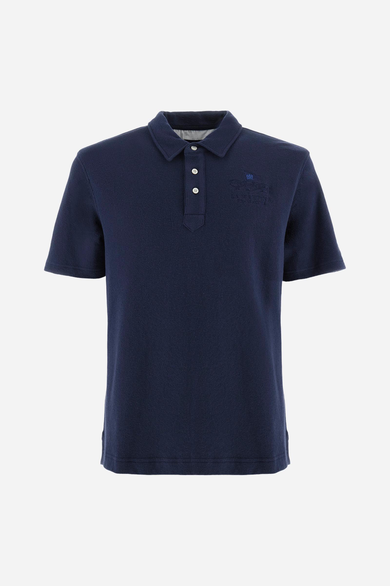 Men's plain short-sleeved polo shirt made from brushed jersey. Three-button fastening. The embroidery on the left side of the chest, in contrasting thread, is inspired by the French Riviera. A small logo is embroidered on the left sleeve, also using contrasting thread. Regular fit. The model is wearing a size L. - Navy
