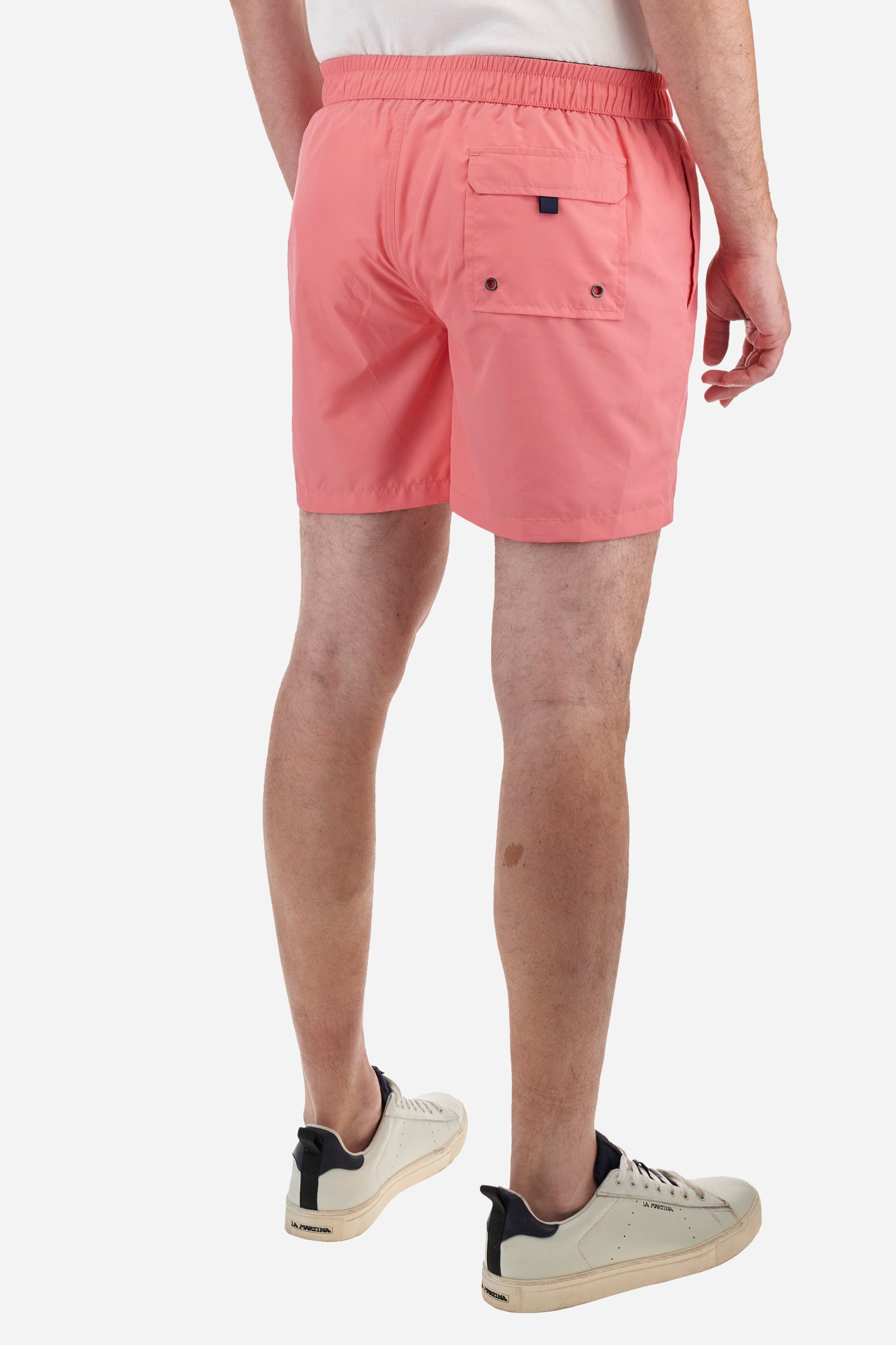 Plain men's swimming shorts made of nylon. Elastic waistband with a personalised drawstring for waist adjustment. On the inside of the shorts is an elasticated mesh brief. Double side pocket on the hips and patch pocket with flap on the back, on the right side only. The large logo is embroidered in a contrasting colour thread on the bottom of the left leg on the front. Regular fit. The model is wearing a size L. - Pink Lemonade