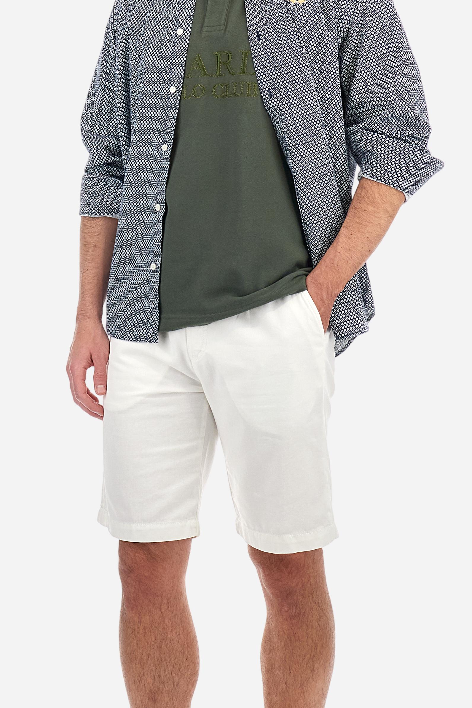 Men's short-sleeved Guards polo shirt in a single colour, made of cotton piqué. Fastens with two buttons. The collar is ribbed with striped trim in a contrasting colour. The graphics on the chest and sleeves are all made using the embroidery technique. The central lettering on the chest is a 3D embroidery in the same colour as the base fabric. The large colour-contrasting logo is embroidered on the chest. The fit is regular. The model is wearing a size L. - Thyme