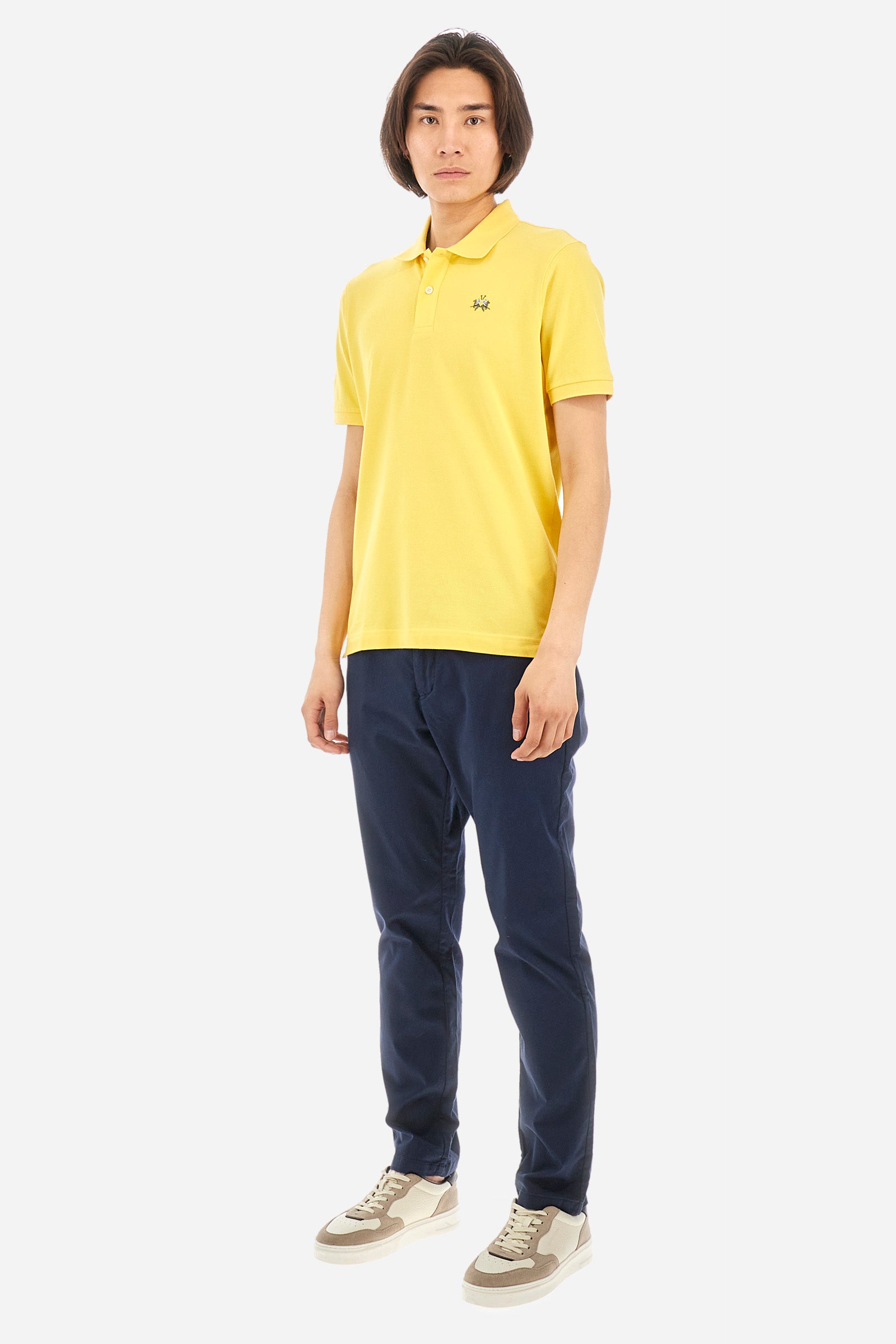 Men's single-colour short-sleeved polo in elasticated cotton. Two-button fastening. Tone-on-tone stitching. Ribbed collar and armholes. The "La Martina" lettering can be found under the collar. Featuring a small logo embroidered on the chest. In a slim fit. The model wears a size L. - Aspen Gold