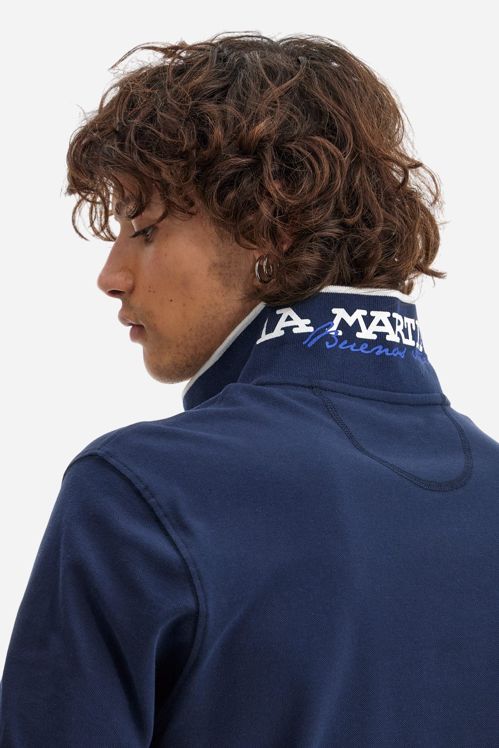 Short-sleeved, single-colour men's polo shirt made of stretch cotton piqué. Fastens with two buttons. The collar and cuffs are ribbed, and there is a colour-contrasting trim at the bottom of the collar. Inside the collar there is a grosgrain ribbon of a different shade. The logo is embroidered on the chest in a contrasting colour. The fit is slim. The model is wearing a size L. - Navy