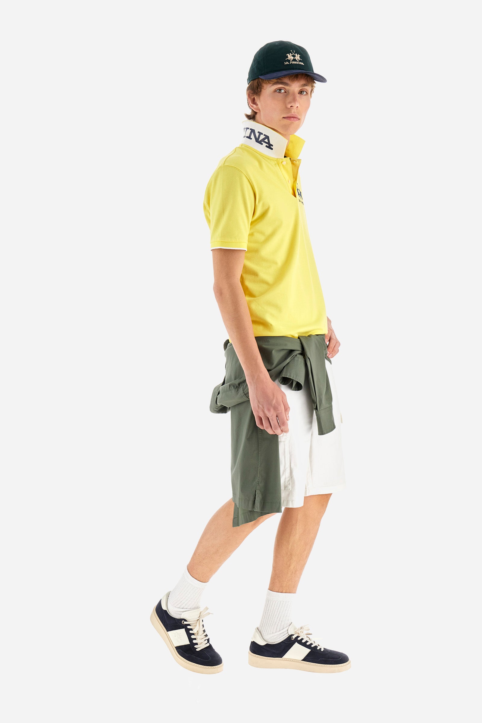 Men's plain short-sleeved polo shirt made from stretch piqué. Featuring a two-button fastening and a ribbon on the inside collar in contrasting coloured grosgrain. The collar and cuffs are in matching rib knit, with the undercollar also in rib knit but in a contrasting colour. The large logo is embroidered on the chest, left side with contrasting coloured thread. The undercollar features a print of the La Martina lettering in a contrasting colour. Regular fit. The model is wearing a size L. - Aurora