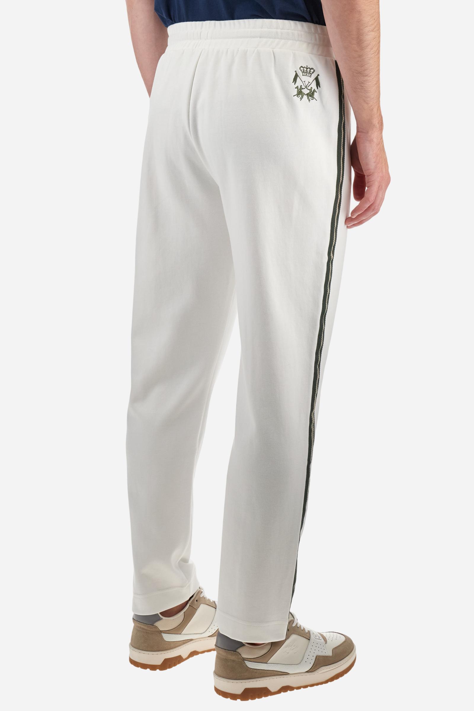 Single-colour men's jogging trousers made of lightweight cotton-blend interlock fleece. Drawstring waistband. Side pockets with matching zip fastening. On both sides, there are multicoloured striped jersey bands. The front features vertical ribbed detailing. The logo is embroidered in colour-contrasting thread on the back, under the strap, towards the right side. Regular fit. The model is wearing a size L. - Off White