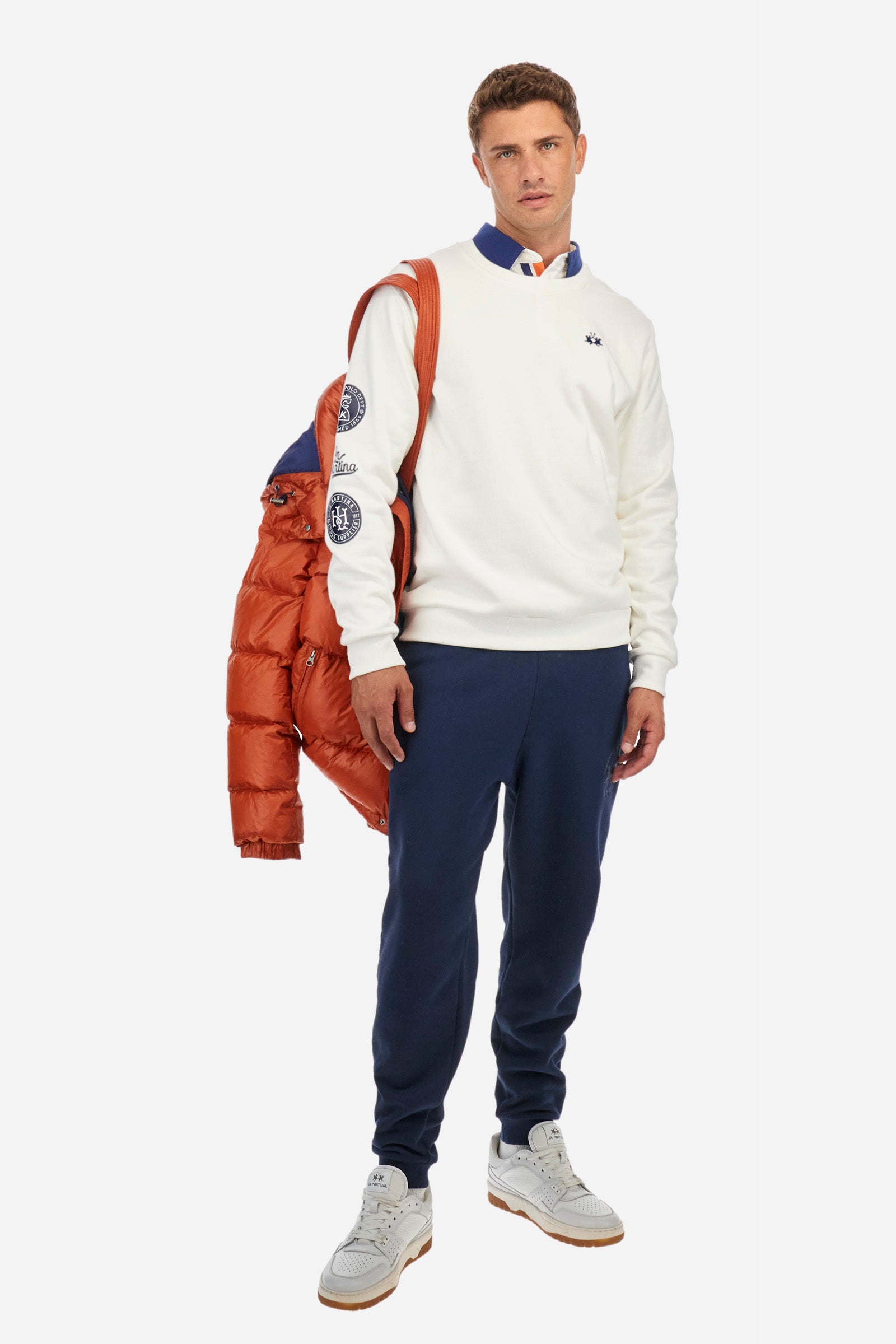 Men's long-sleeved crew neck sweatshirt, made from plain 100% cotton. Ribbed hem, neckline and cuffs. One of the sleeves is finished with symbols and the words La Martina. The logo is embroidered on the front. Regular fit. The model is wearing a size L. - Off White