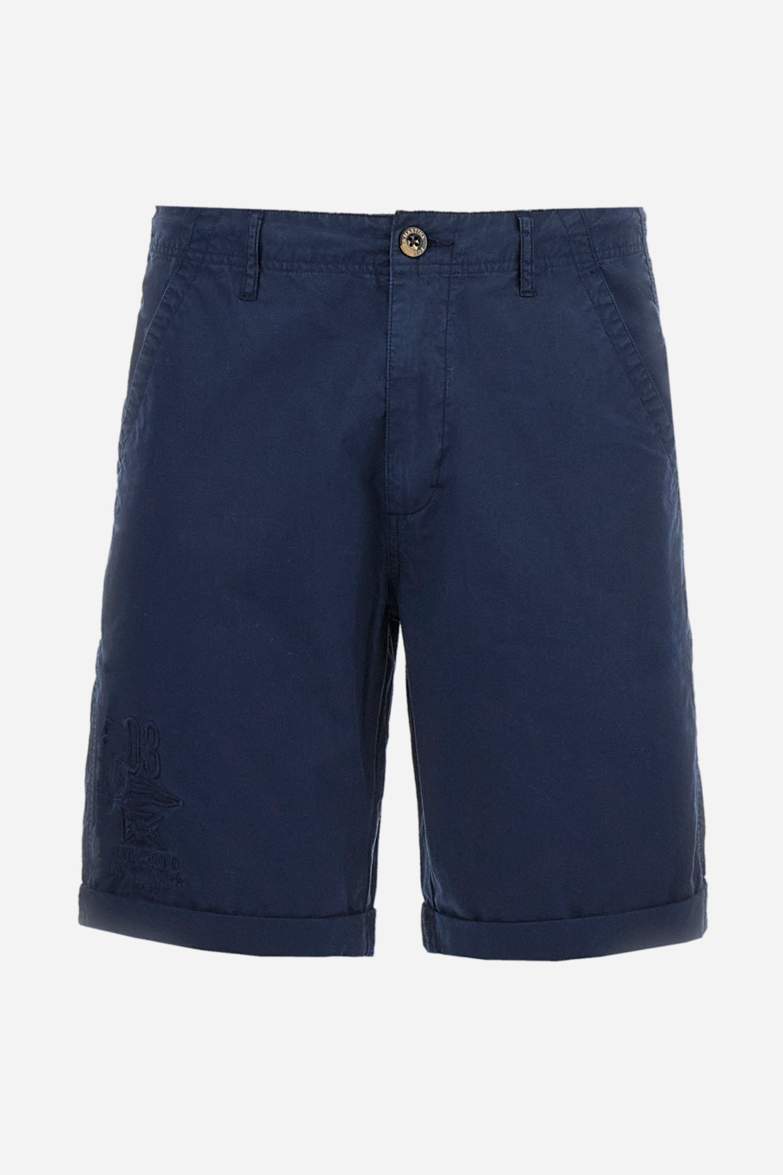 Men's plain Bermuda shorts made from cotton poplin. Fastened with a zip and faux horn button, they feature turn-ups at the hems for a touch of style. The side slant pockets are extremely practical, and the flap patch pockets on the back are fastened with faux horn buttons. Above the right pocket, a woven label explains the brand's quality certification. On the right leg, near the hem, there is an embroidered graphic with numbers and tone-on-tone lettering. Regular fit. The model is wearing a size 33. - Navy