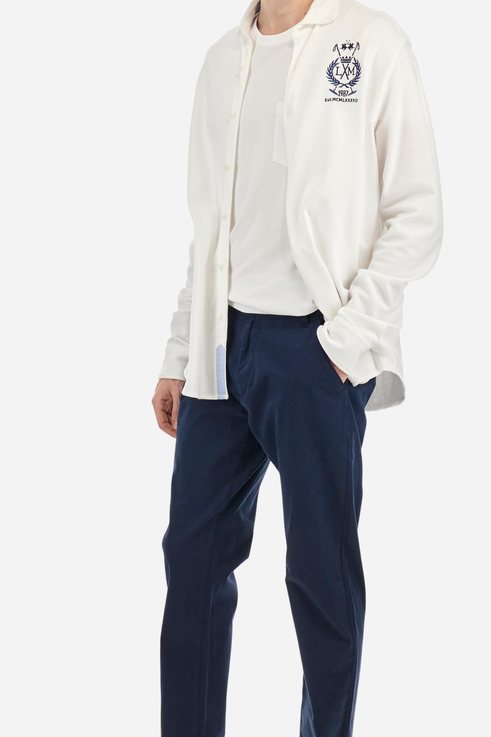 Single-colour men's chino trousers made of elasticated cotton twill. Zip fastening and faux horn button. Side slash pockets and folded waistband. On the back there are welt pockets with a flap and hidden button. The right front loop has a metal rivet with the flag of Argentina as an applied detail. Regular fit. The model is wearing a size 33. - Navy