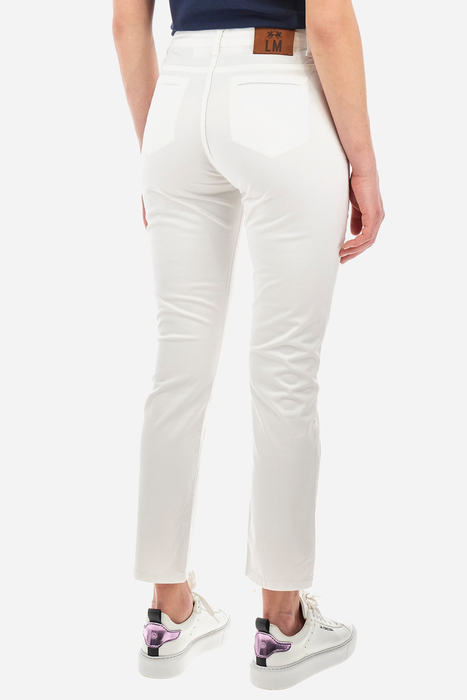 Women's single-colour cigarette trousers in elasticated cotton. With belt loops, zip and jewel button fastening. Double open front pocket and double open pocket on the back. Side slits at the bottom of the garment. The logo can be found on a patch applied between the loops. The fit is regular. The model wears a size 28. - Optic White