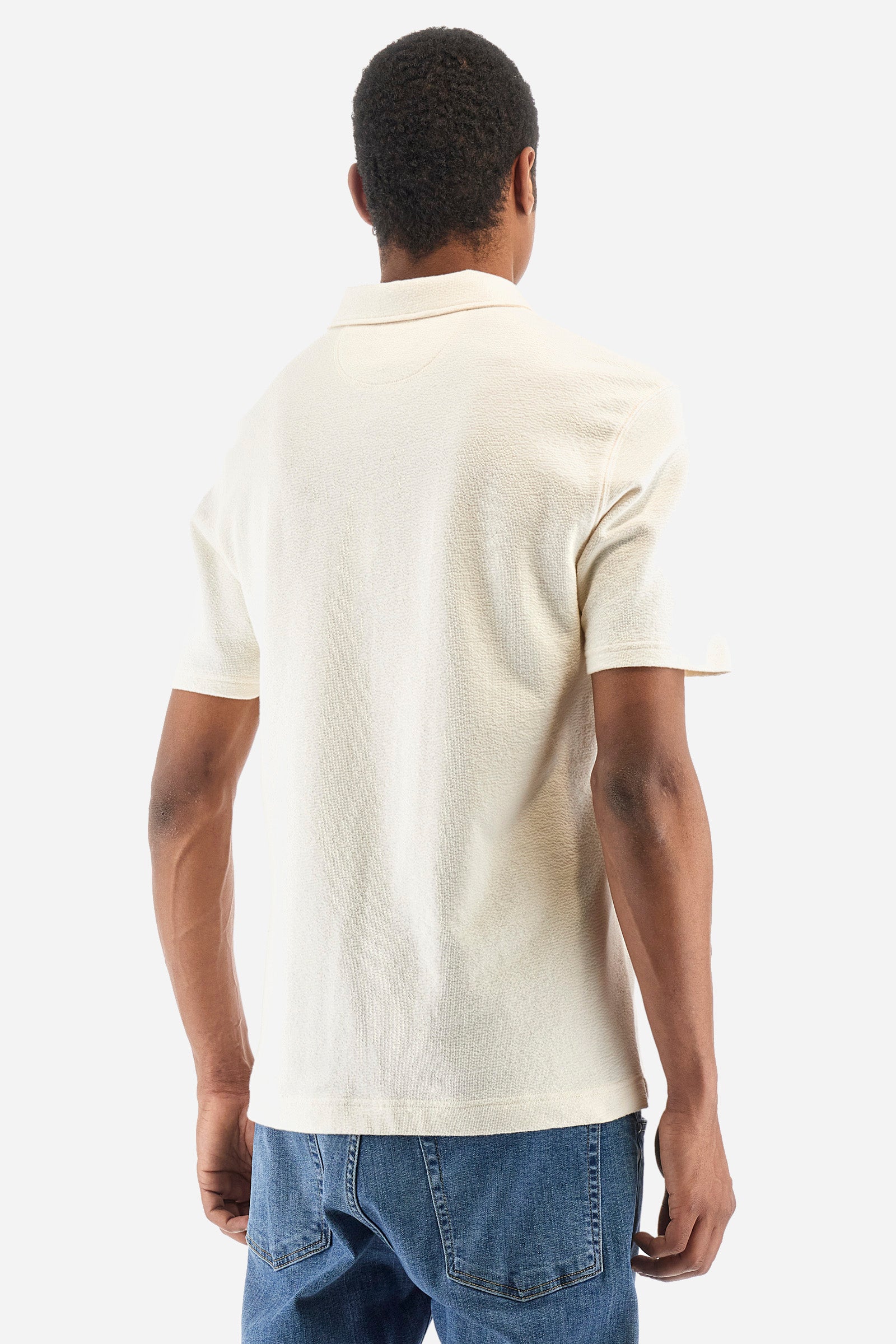 Men's single-colour short-sleeved polo shirt in 100% cotton. Fastens with a button. Tone-on-tone stitching. Pointed collar. Featuring a small embroidered logo on the front. The fit is regular. The model wears a size L. - Off White