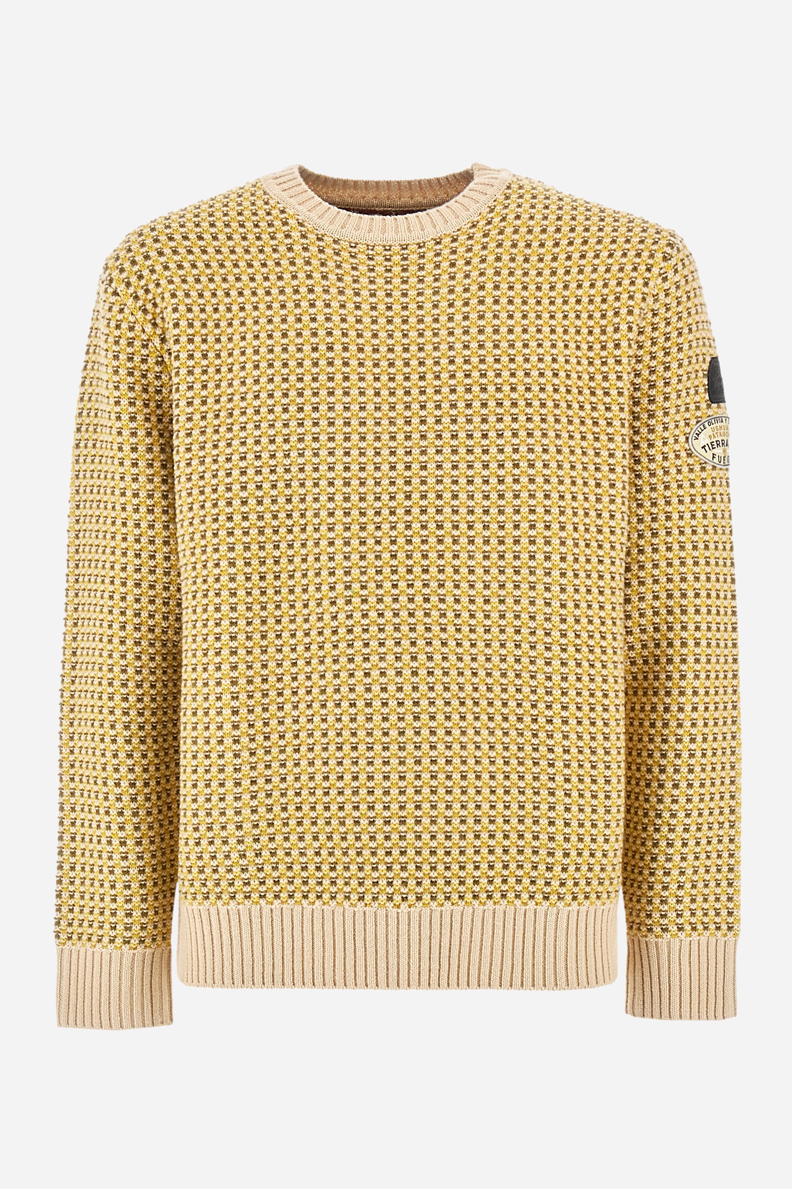 Men's crewneck pullover with long sleeves, made from a wool-blend yarn. The jacquard pattern differs on the front and sleeves, featuring a micro-check effect, while the back showcases a larger pattern with horizontal blocks. The collar, hem, and cuffs are in solid ribbed fabric. A patch inspired by Tierra del Fuego and a rubberized logo patch are applied on the sleeve. The fit is comfortable. - Jacquard Multicolour