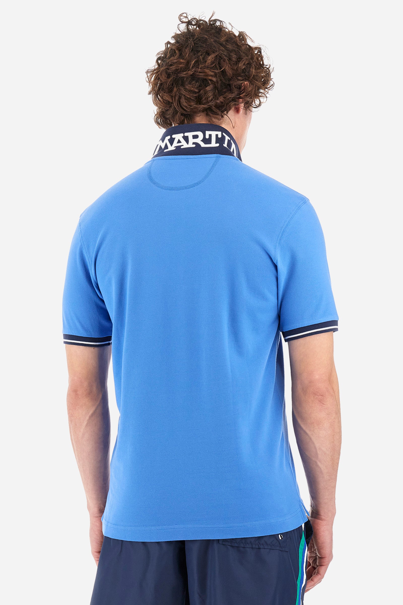 Men's single-colour short-sleeved polo in elasticated cotton. Fastens with two contrasting buttons. Ribbed collar and armholes in different shades. The "La Martina" lettering can be found under the collar. A large logo is embroidered on the chest. The fit is slim. The model wears a size L. - Campanula