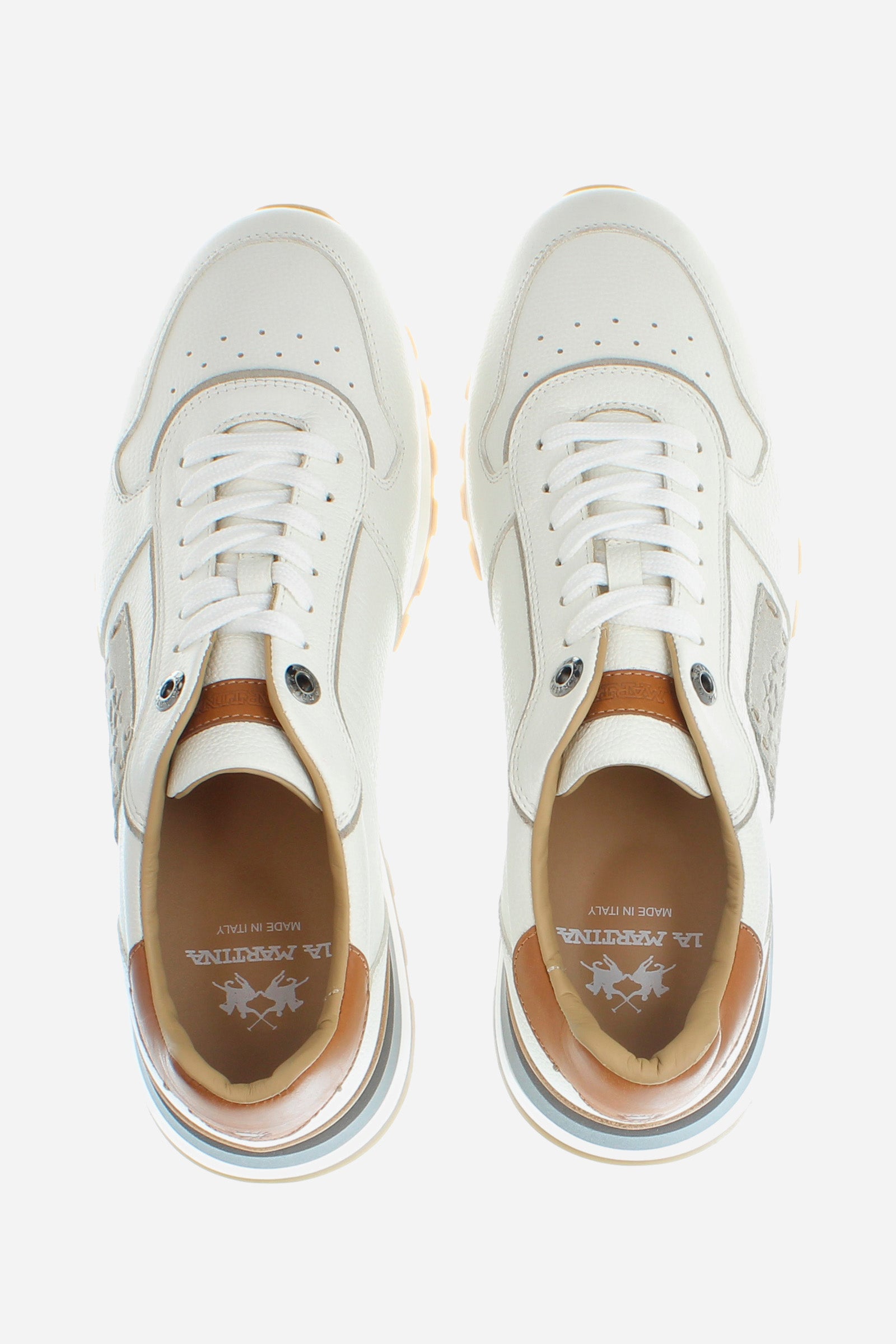 Men's calfskin trainer with hand-stitched side band in a contrasting tone, with an embossed La Martina logo. This shoe displays great attention to detail: from the contrasting lacing profile, which creates a dynamic effect, to the leather and suede inserts on the back or to the leather spoiler on the heel. The aged effect of the leather on the upper gives the shoe an unmistakably artisanal touch. Perfect for a gritty look with details that evoke the classicism of the La Martina brand. - WHITE/IVORY