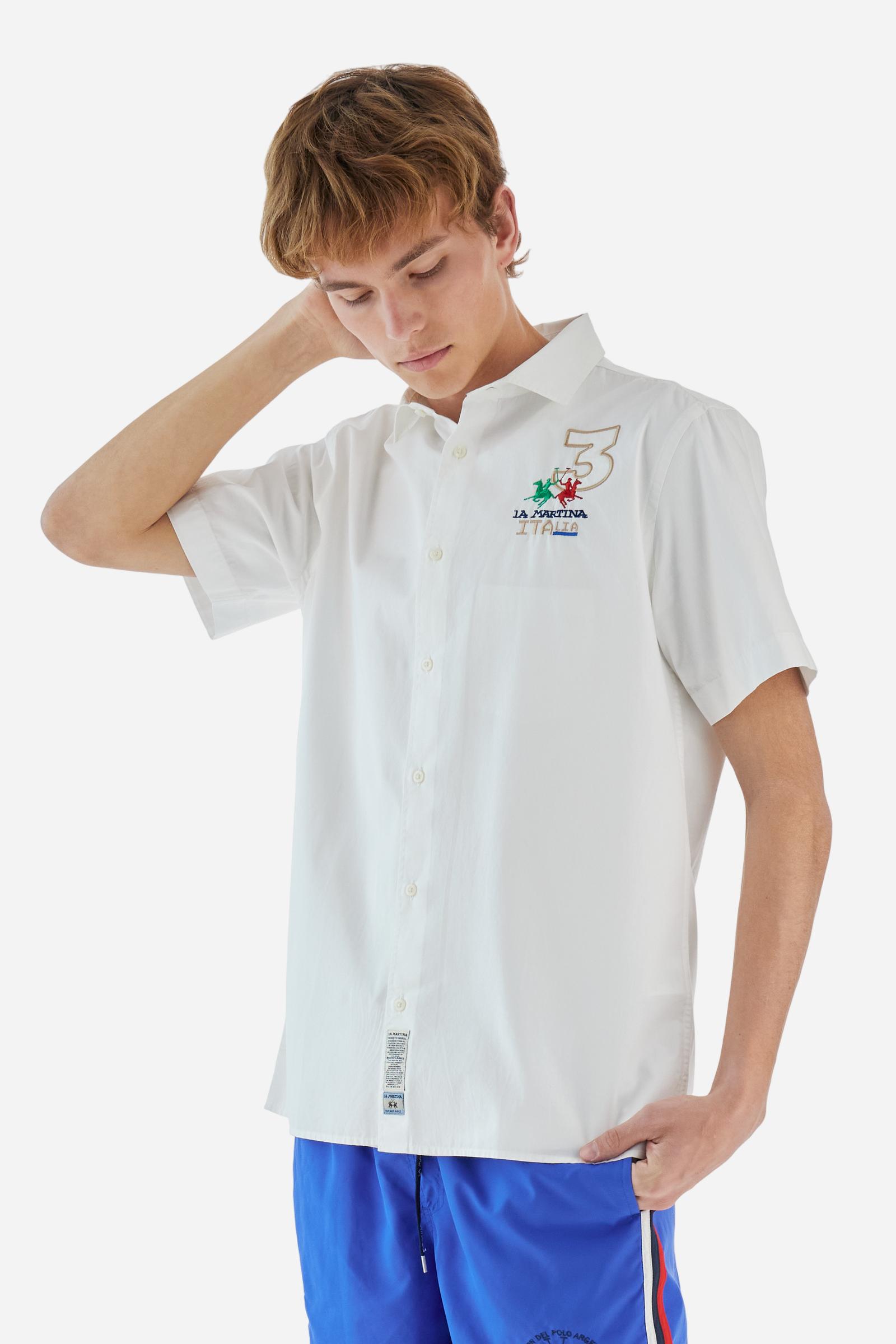 Men's plain short-sleeved shirt made from cotton poplin. Spread collar and straight hem. The embroidered logo on the chest, over the heart, is designed in the colours of the Italian flag. On the back, the combination of printing and embroidery techniques – depicting lettering, numbers and logos – are enriched with 3 ribbons in the colours of the Italian flag, appliquéd vertically. Regular fit. The model is wearing a size L. - Optic White
