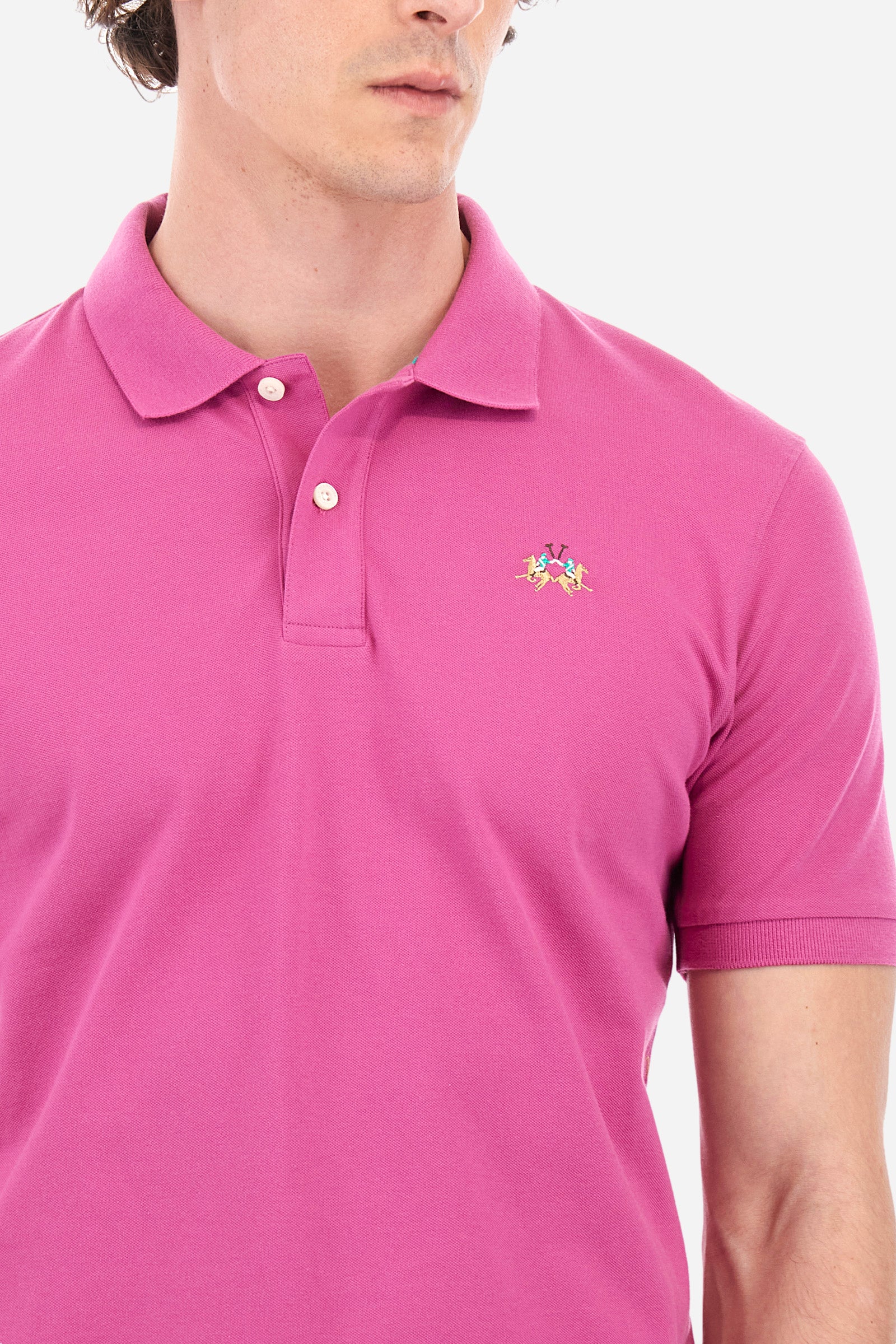 Men's single-colour short-sleeved polo in elasticated cotton. Two-button fastening. Tone-on-tone stitching. Ribbed collar and armholes. The "La Martina" lettering can be found under the collar. Featuring a small logo embroidered on the chest. In a slim fit. The model wears a size L. - Purple Wine