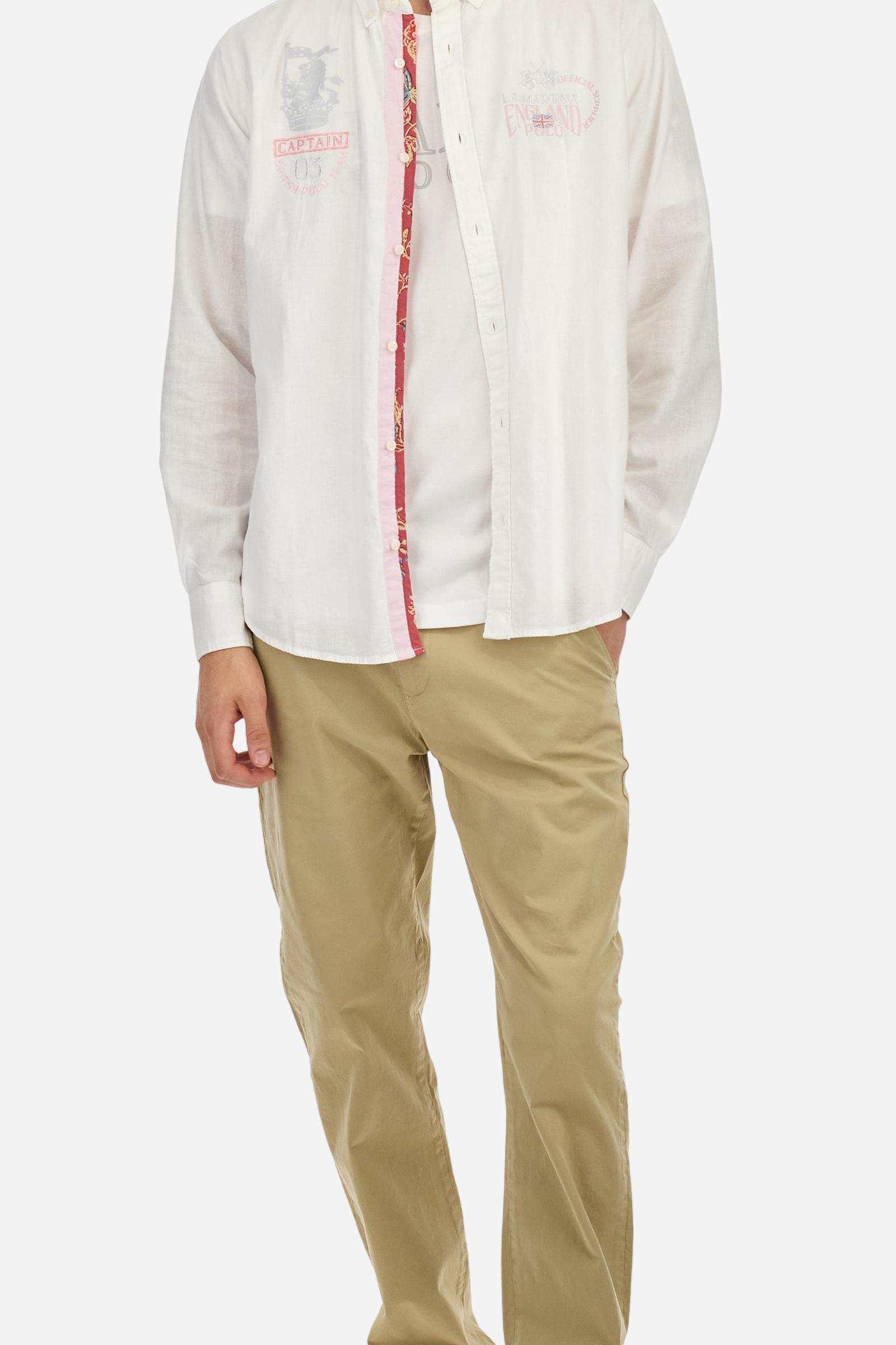 Men's long-sleeved single-colour shirt made of cotton and linen canvas. Button-down collar. Featuring details on the inside of the collar and opening in contrasting colour printed fabrics. The front graphics and logo are embroidered with contrasting colour threads. The fit is regular. The model is wearing a size L. - Optic White