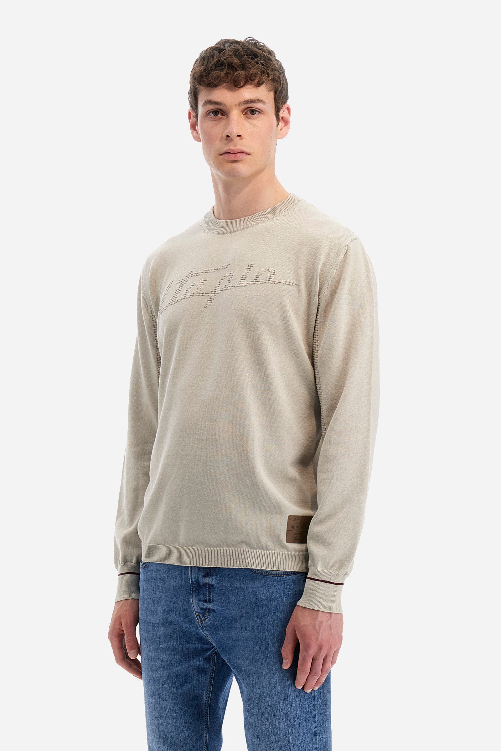 Men's long-sleeved crew-neck jumper in a single colour in collaboration with Pagani. Made from 100% cotton. Some parts of the garment have a woven basket stitch texture. Ribbed cuffs, neck and waist. The front features the line's characteristic lettering. The logo and "La Martina" and "Pagani" lettering are present on the patch representing the collaboration applied on both the front and back. The fit is regular. The model wears a size L. - Rainy Day
