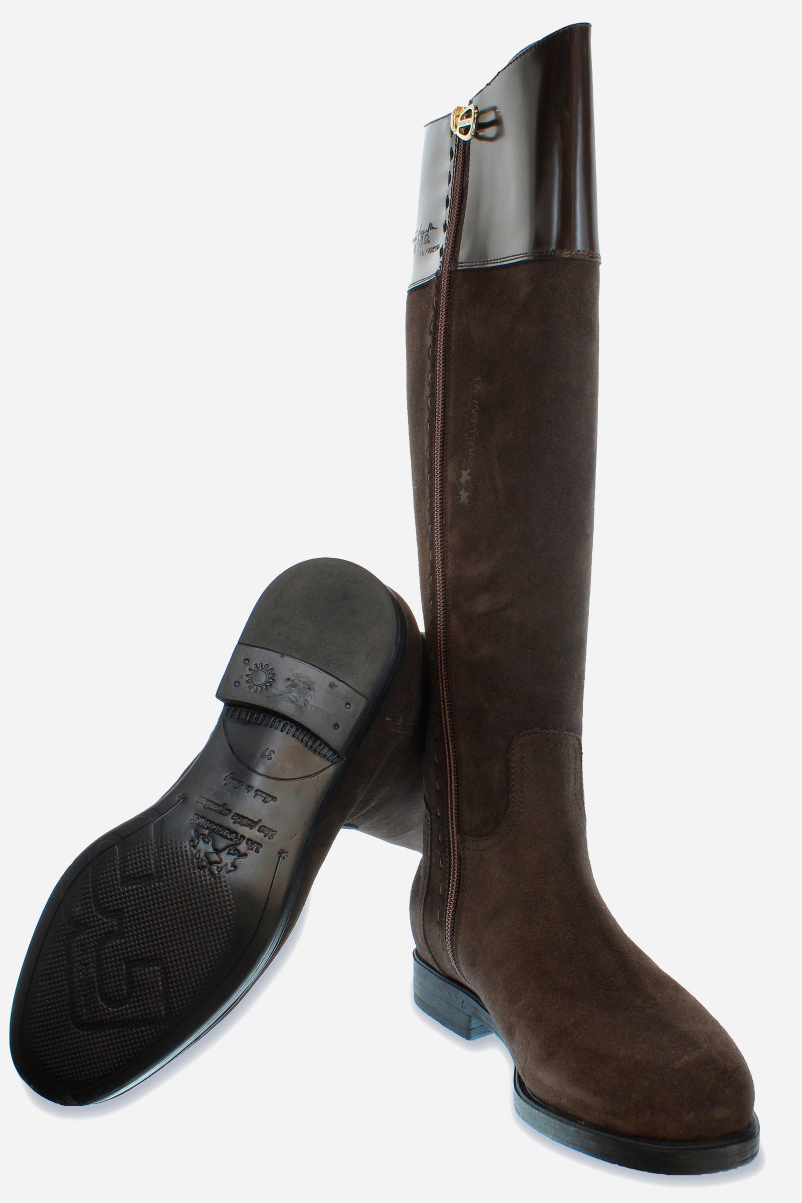 A clean-cut, equestrian-inspired women's boot in suede with soft cowhide at the top of the boot leg.An emblematic model with the unique savoir-faire of La Martina. The horse logo is embossed on the side upper leg. Customised metal rivet detailing on the lower side. This is complemented by the craftsmanship of the hand-stitching. With an extremely versatile and current country chic style. - DARK BROWN