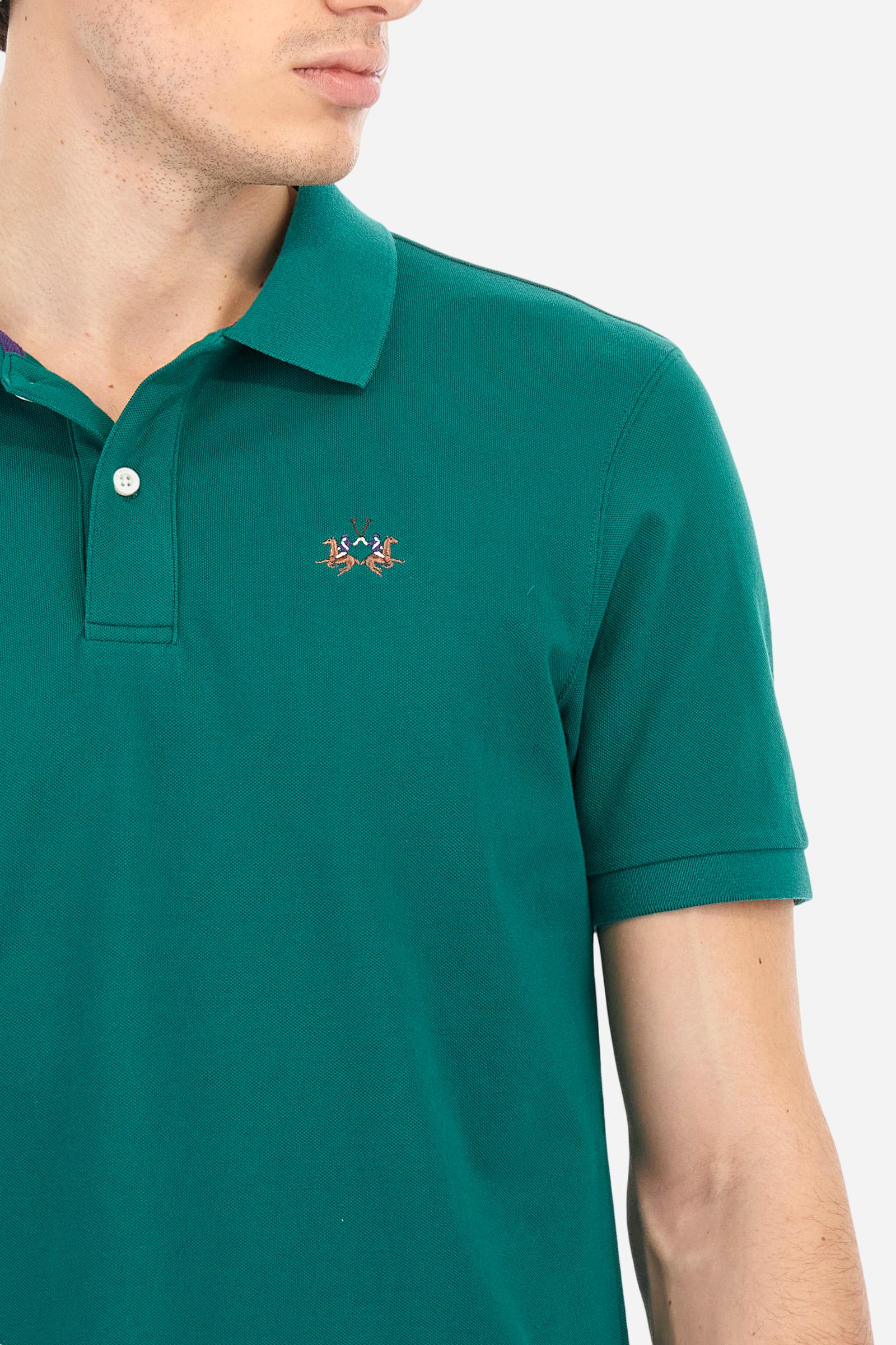 Men's plain short-sleeved polo shirt made from stretch piqué. Two-button fastening. The collar and cuffs are made from tone-on-tone ribbed fabric. Under the collar, there is a contrasting fabric panel with embroidered multicoloured lettering. The logo is embroidered on the left side of the chest in contrasting thread. Slim fit. The model is wearing a size L. - Evergreen