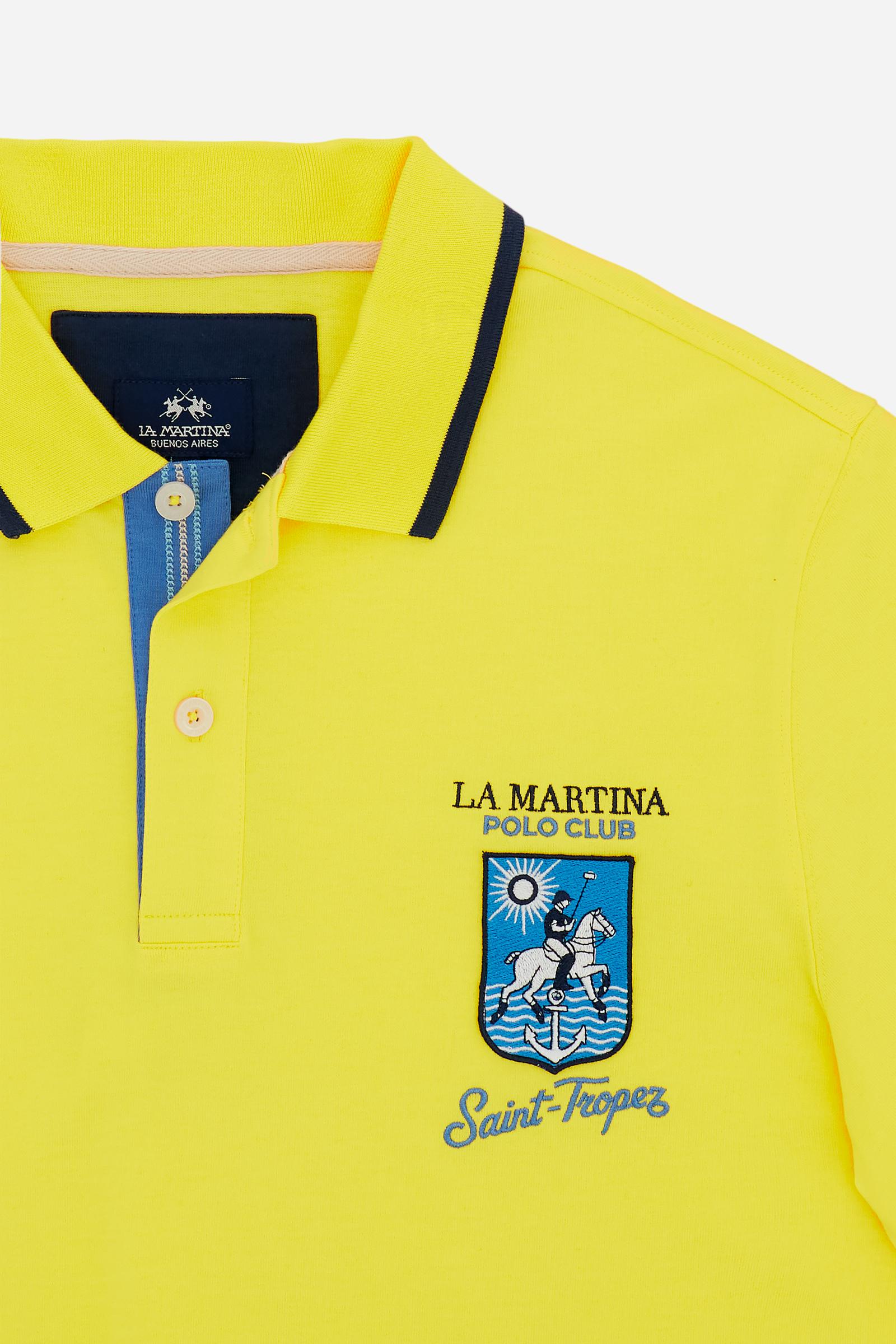 Men's short-sleeve polo shirt made from heavy-weight cotton jersey in solid color. The model features a front opening in contrasting jersey with vertically embroidered chain stitching. The collar and cuffs are ribbed with contrasting edge detail. The design is enriched with an embroidered crest on the chest dedicated to Saint Tropez and the iconic two polo players logo embroidered on the back. The fit follows modern trends with a slightly oversized silhouette, dropped shoulders and a relaxed shape. The mode