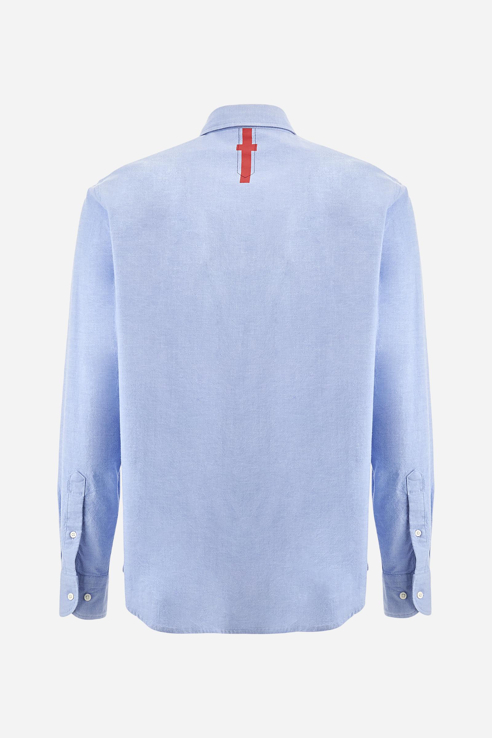 Men's long-sleeved plain shirt made from 100% Oxford cotton. The button-down collar is finished with a second button printed with the English flag. The multicoloured embroidery on the chest, over the heart, includes lettering, numbers and the logo, which add a distinctive touch. Regular fit. The model is wearing a size L. - Cornflower blue