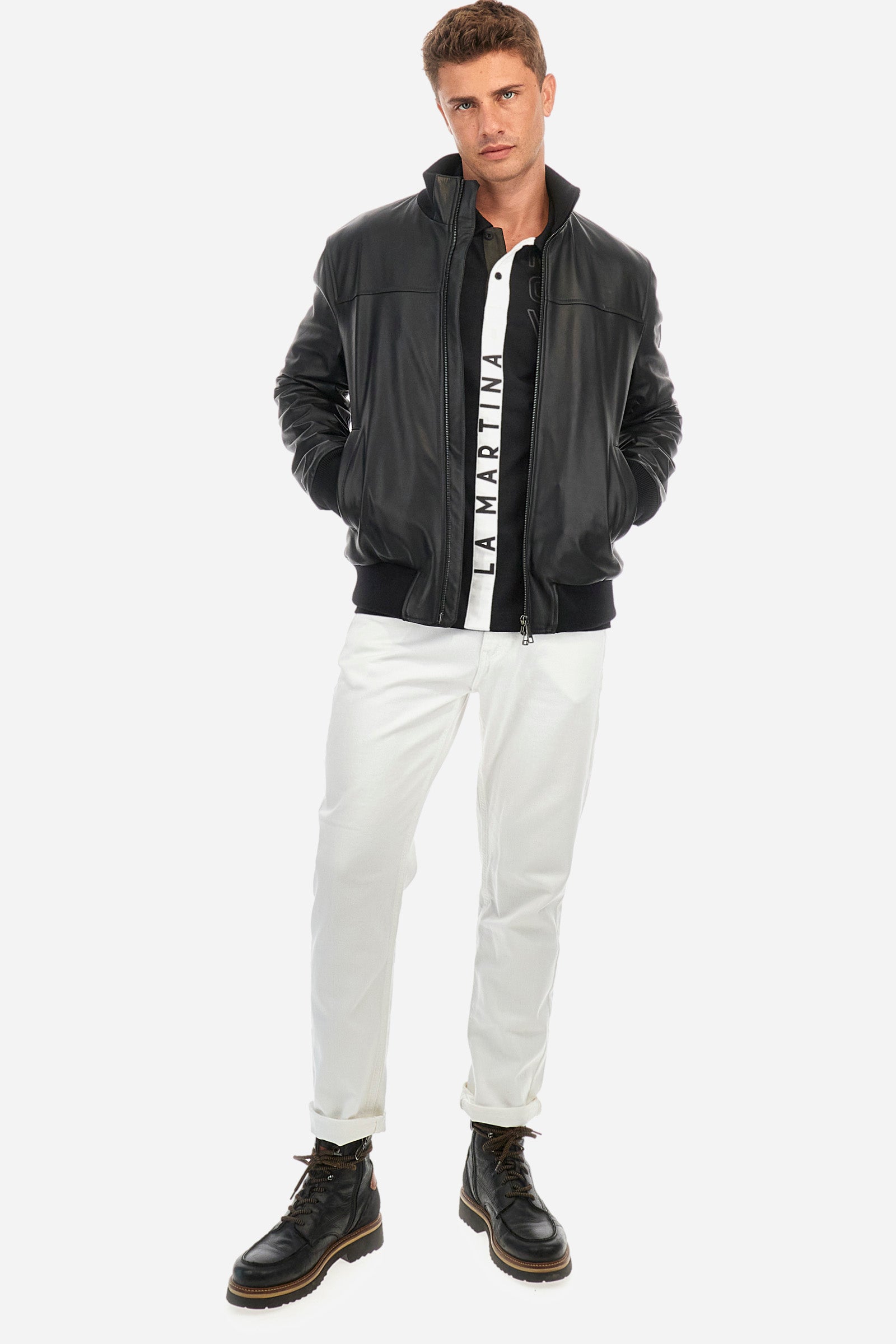 Men's single-colour long-sleeved polo shirt, made from 100% cotton. Two-button fastening. Profiled collar. In the centre of the garment is a contrasting colour stripe with La Martina printed on it. A patch and lettering are applied on the front. Regular fit. The model is wearing a size L. - Black