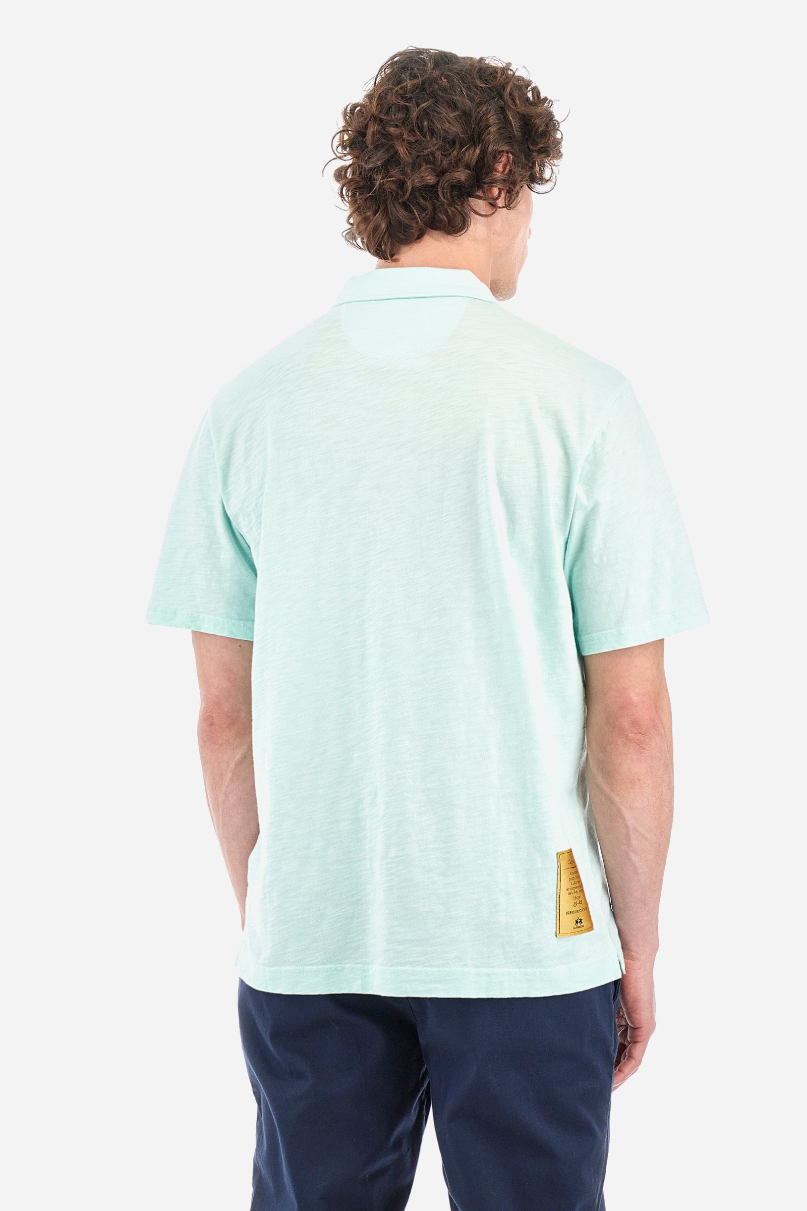 Men's single-colour short-sleeved polo shirt in 100% cotton. Fastens with a button. Tone-on-tone stitching. Pointed collar. Featuring a small embroidered logo on the front. The fit is regular. The model wears a size L. - Honeydew