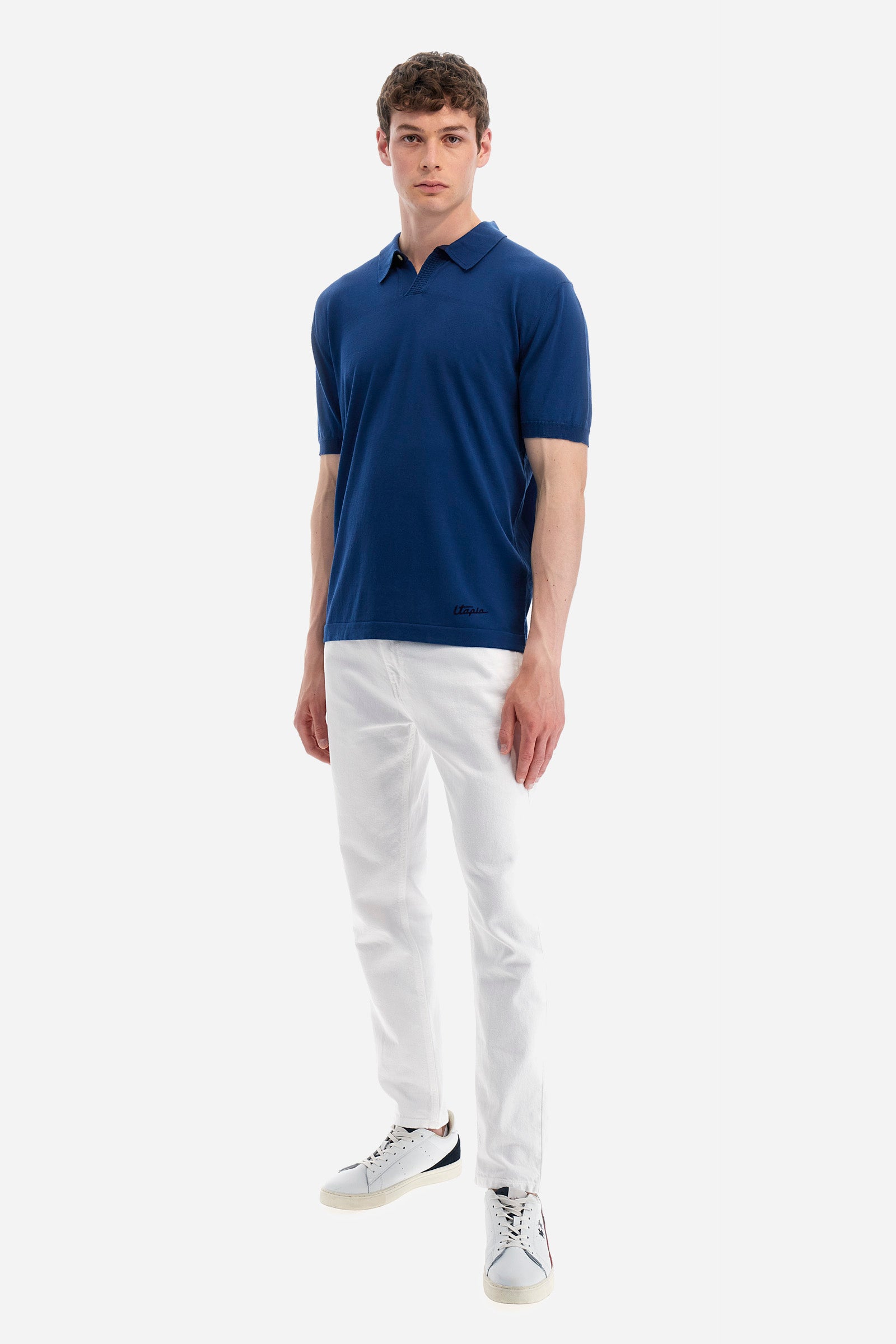 Single-colour men's knitted polo shirt with short sleeves from the line in collaboration with Pagani. Made of 100% cotton. Fastens with a button. Ribbed armholes and waist. The logo and "La Martina" and "Pagani" lettering are present on the patch representing the collaboration applied on the back. The fit is regular. The model wears a size L. - Ensign Blue
