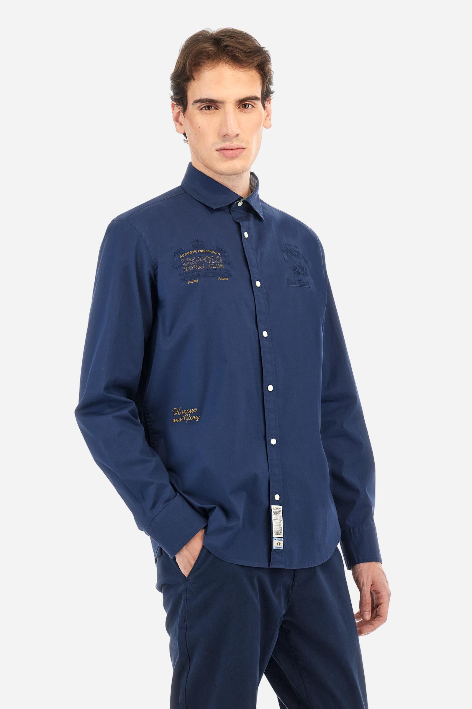 Men's single-colour long-sleeved shirt, made from 100% cotton poplin. Spread collar. Featuring details inside the collar and cuffs in contrasting colours and fabrics. The front graphics and logo are embroidered with contrasting colour threads. The fit is regular. The model is wearing a size L. - Navy