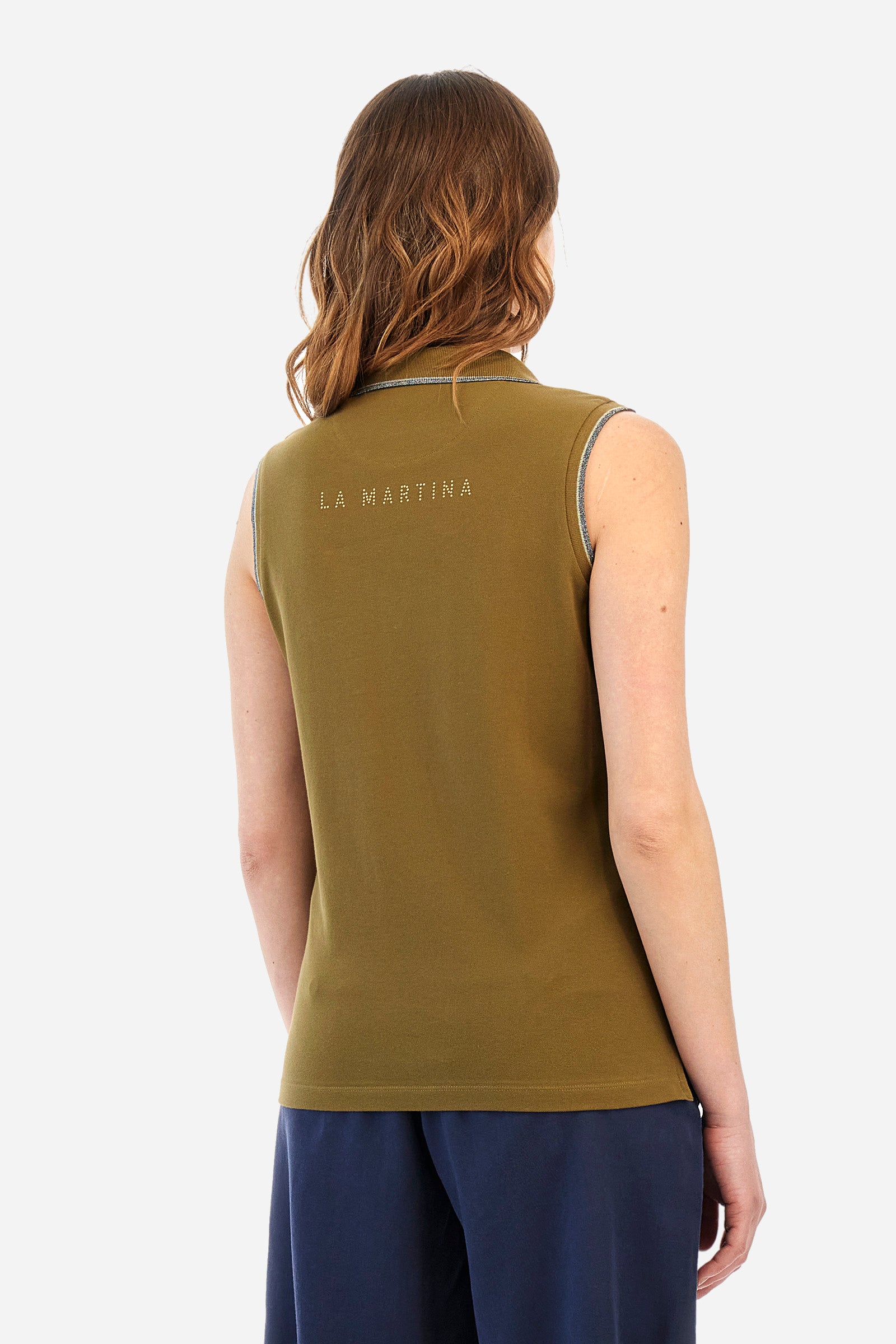Women’s sleeveless polo shirt in solid color, made of stretch cotton. V-neck and 2 button closure. Collar and crew sleeves profiled and ribbed. Side slits. On the back there is the inscription "La Martina" composed of small rhinestones. The logo is present on the front. The fit is regular. The model wears a size 2 . - Military Olive