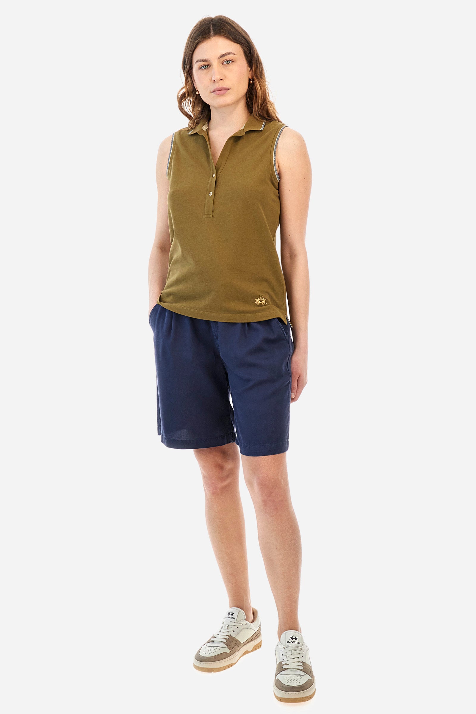Women’s sleeveless polo shirt in solid color, made of stretch cotton. V-neck and 2 button closure. Collar and crew sleeves profiled and ribbed. Side slits. On the back there is the inscription "La Martina" composed of small rhinestones. The logo is present on the front. The fit is regular. The model wears a size 2 . - Military Olive