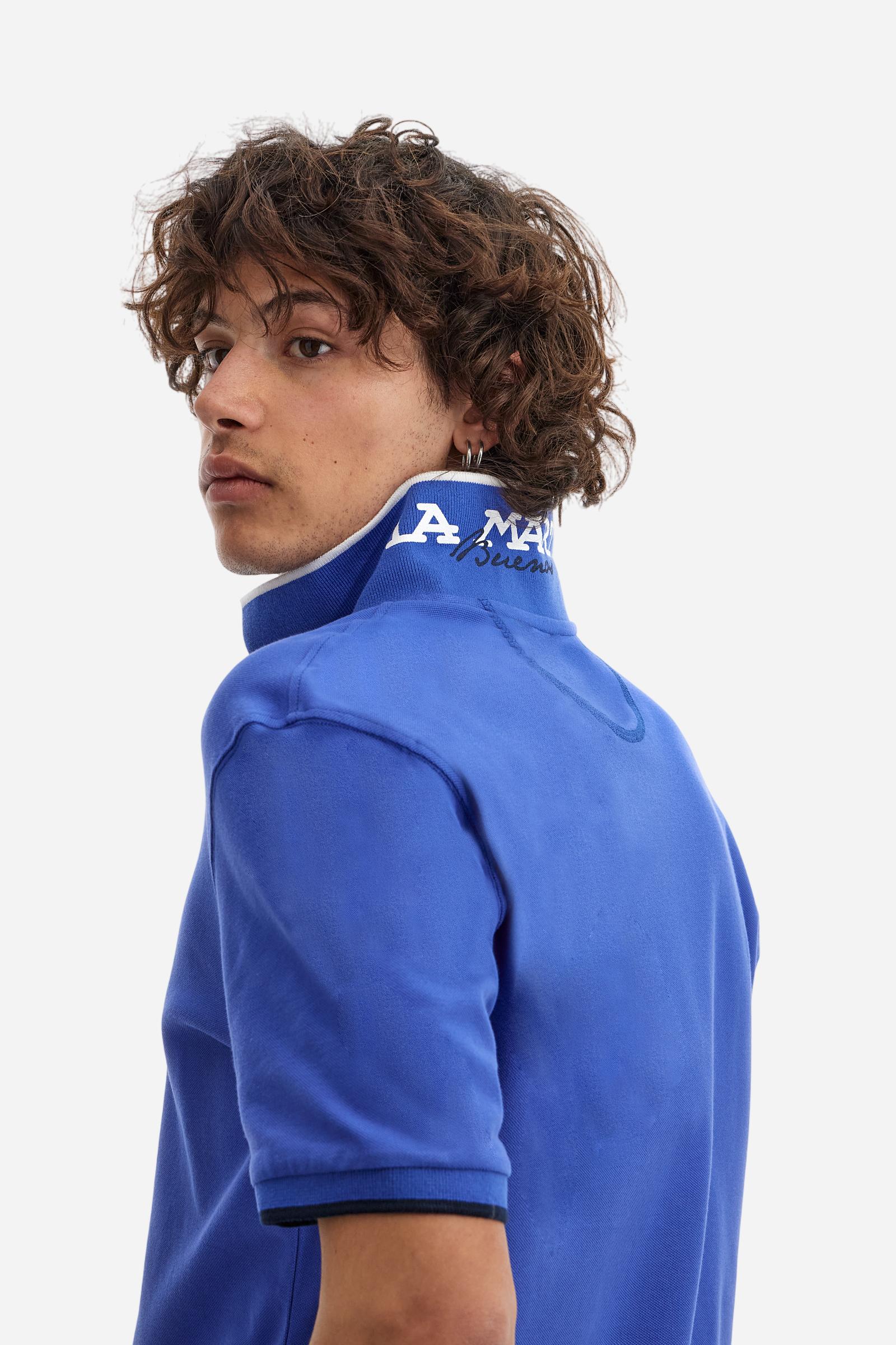 Short-sleeved, single-colour men's polo shirt made of stretch cotton piqué. Fastens with two buttons. The collar and cuffs are ribbed, and there is a colour-contrasting trim at the bottom of the collar. Inside the collar there is a grosgrain ribbon of a different shade. The logo is embroidered on the chest in a contrasting colour. The fit is slim. The model is wearing a size L. - Dazzling Blue