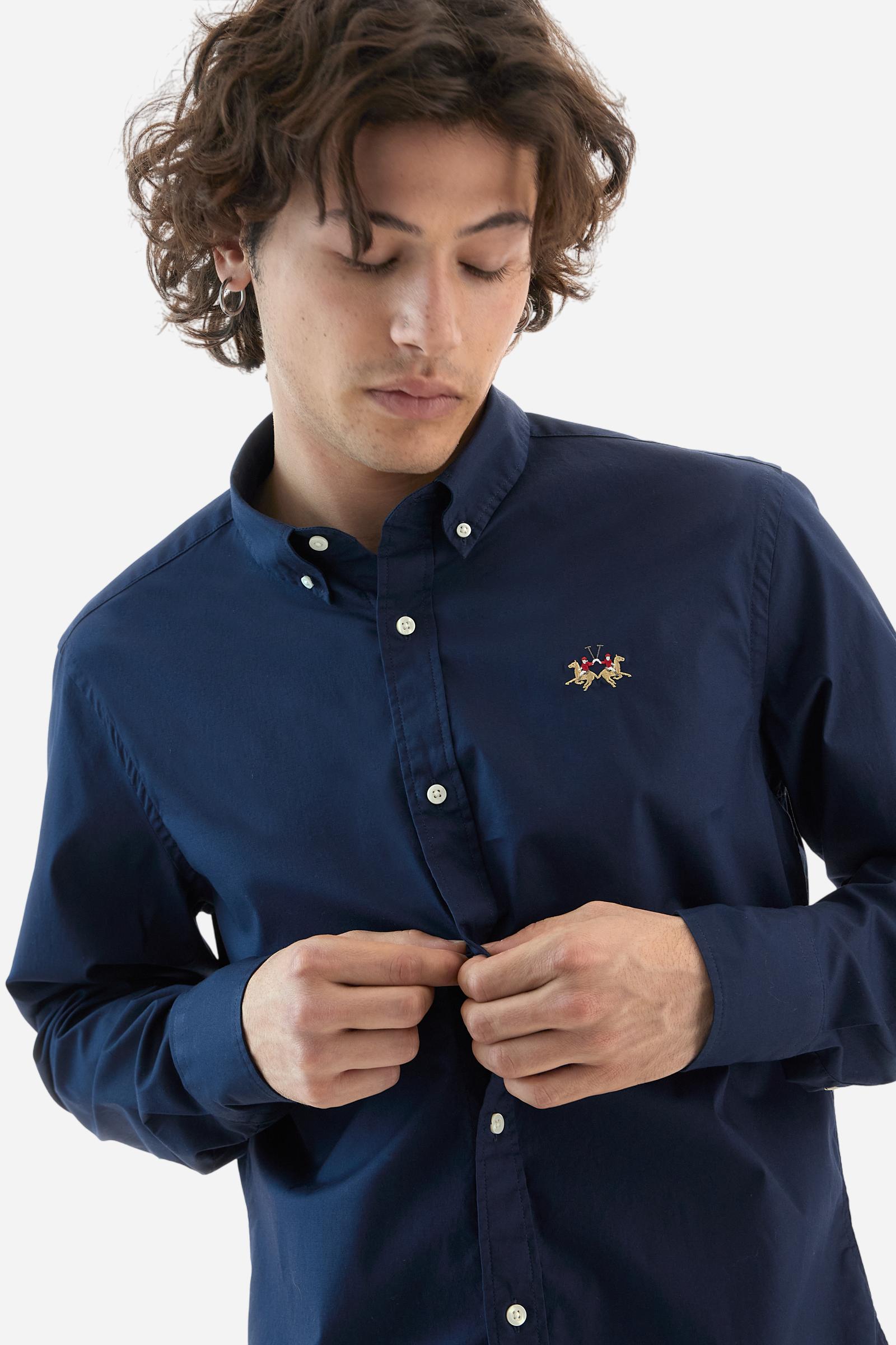 Men's plain long-sleeved shirt made from stretch cotton poplin for a comfortable fit. Featuring a button-down collar and woven labels at the bottom of the opening. A multicoloured logo is embroidered on the chest, over the heart, in contrasting thread. The slim fit ensures a sleek and modern look. The model is wearing a size L. - Navy