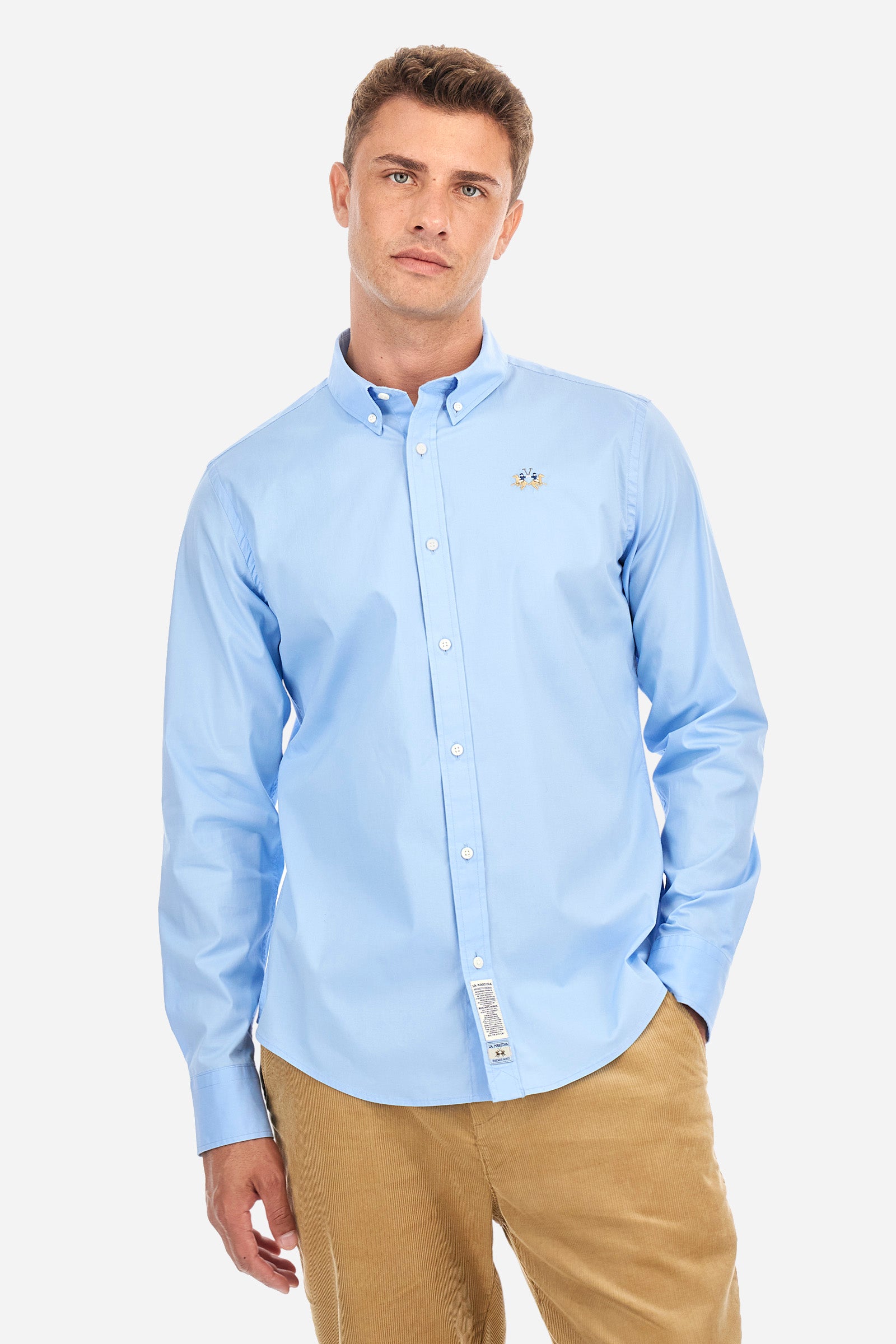 Men's single-colour shirt with long sleeves, made of stretch cotton. Button-down collar. With buttoned cuffs. Featuring a small embroidered logo on the front. Slim fit. The model is wearing a size L. - Blue Bell