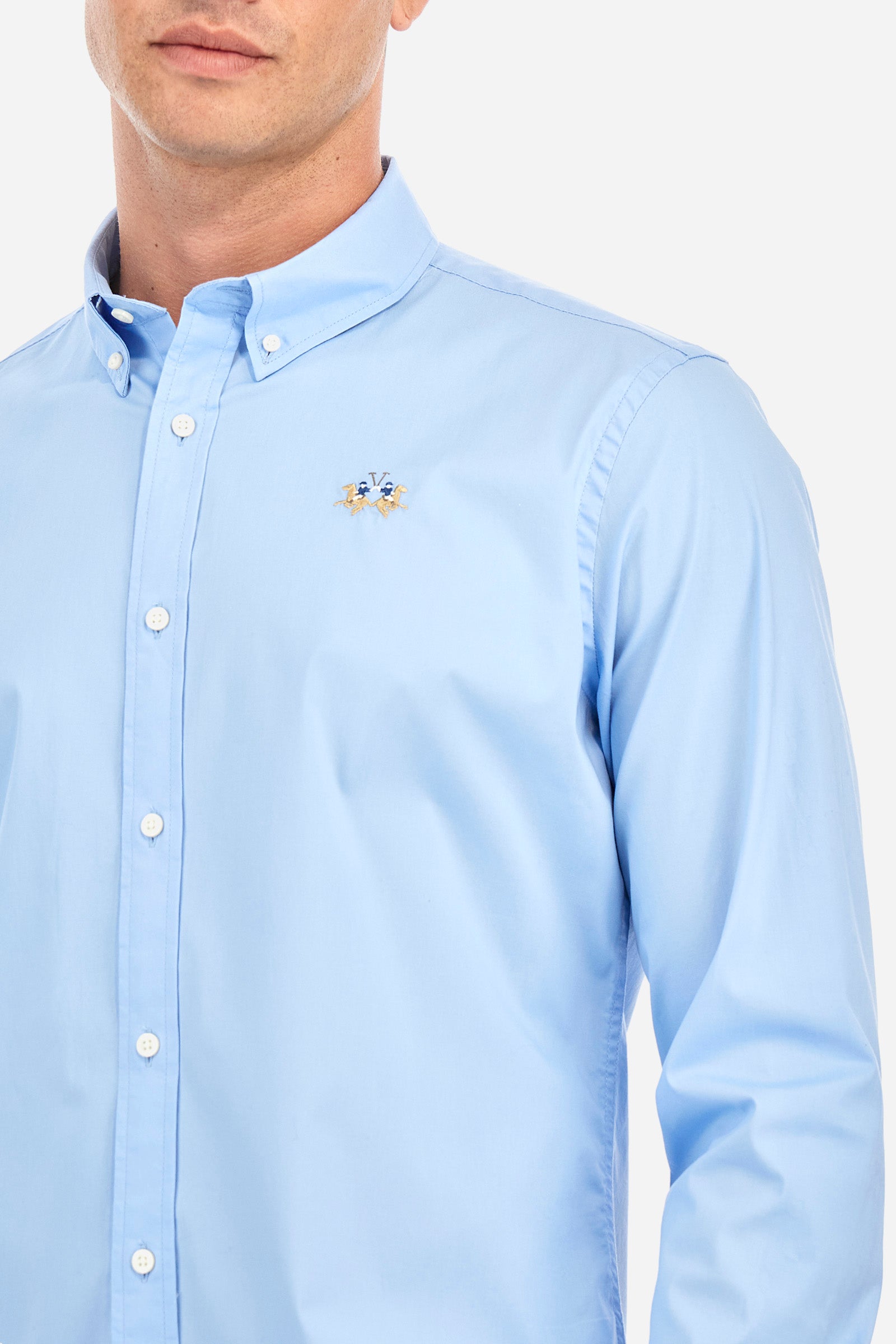 Men's single-colour shirt with long sleeves, made of stretch cotton. Button-down collar. With buttoned cuffs. Featuring a small embroidered logo on the front. Slim fit. The model is wearing a size L. - Blue Bell