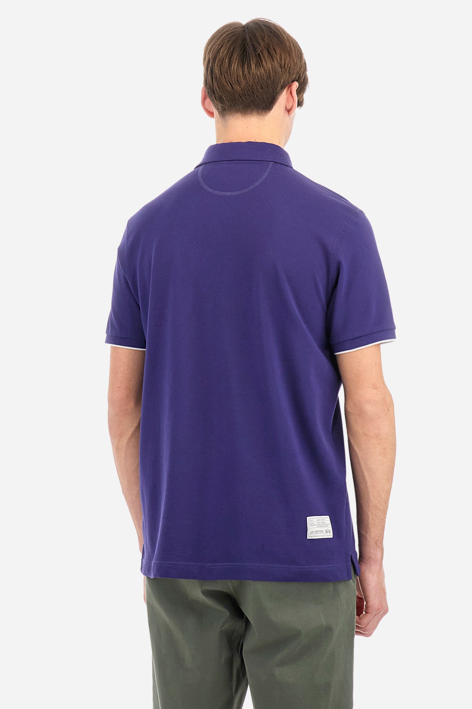 Men's plain short-sleeved polo shirt made from stretch piqué. Featuring a two-button fastening and a ribbon on the inside collar in contrasting coloured grosgrain. The collar and cuffs are in matching rib knit, with the undercollar also in rib knit but in a contrasting colour. The large logo is embroidered on the chest, left side with contrasting coloured thread. The undercollar features a print of the La Martina lettering in a contrasting colour. Regular fit. The model is wearing a size L. - Deep Cobalt