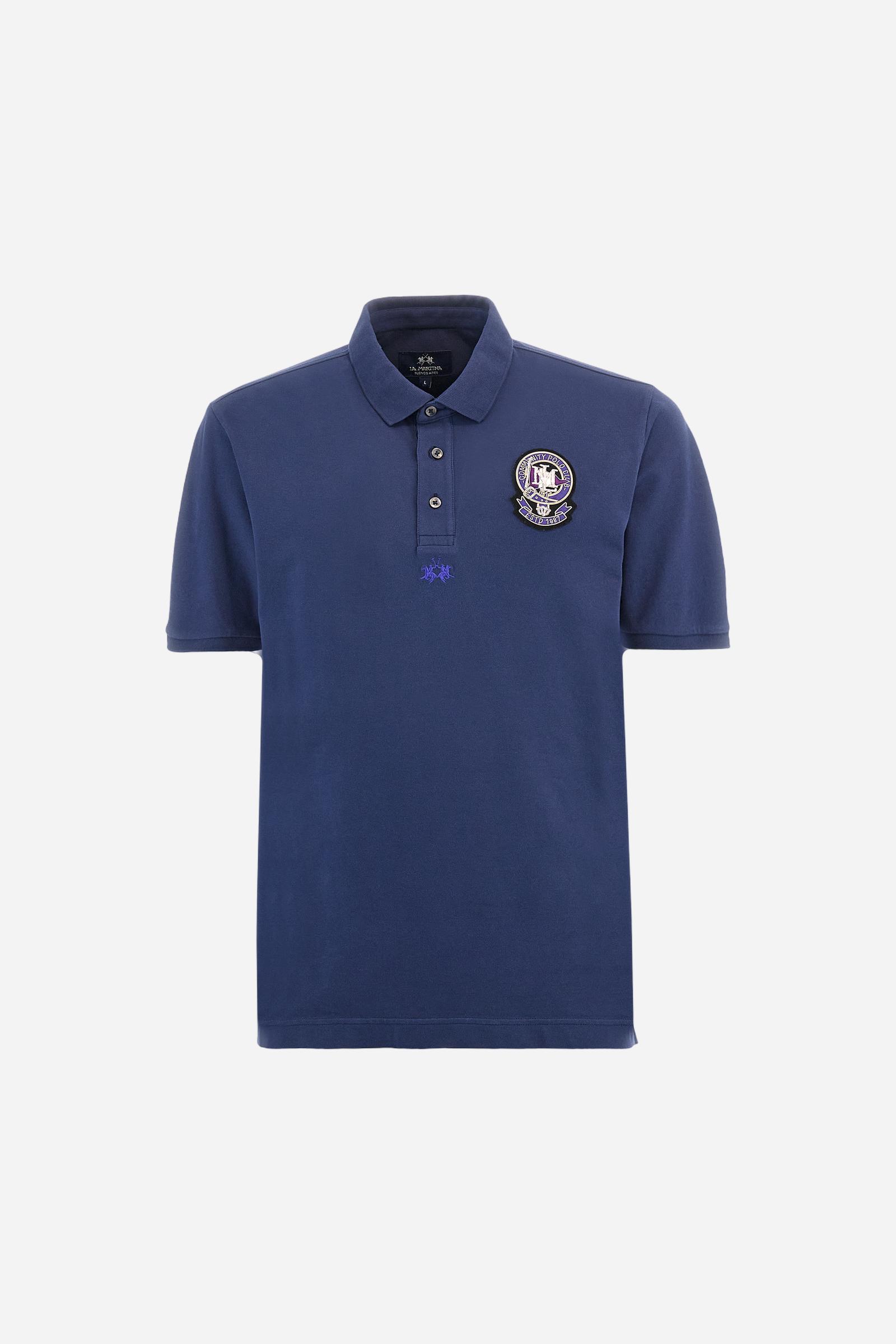 Men's short-sleeved polo shirt in a single colour, made of cotton stretch pique. Fastens with three buttons. Cuffs and collar in rib knit to match the garment. Patch in metallic thread applied on the chest. A colour-contrasting logo is present on the front. Regular fit. The model is wearing a size L. - Navy