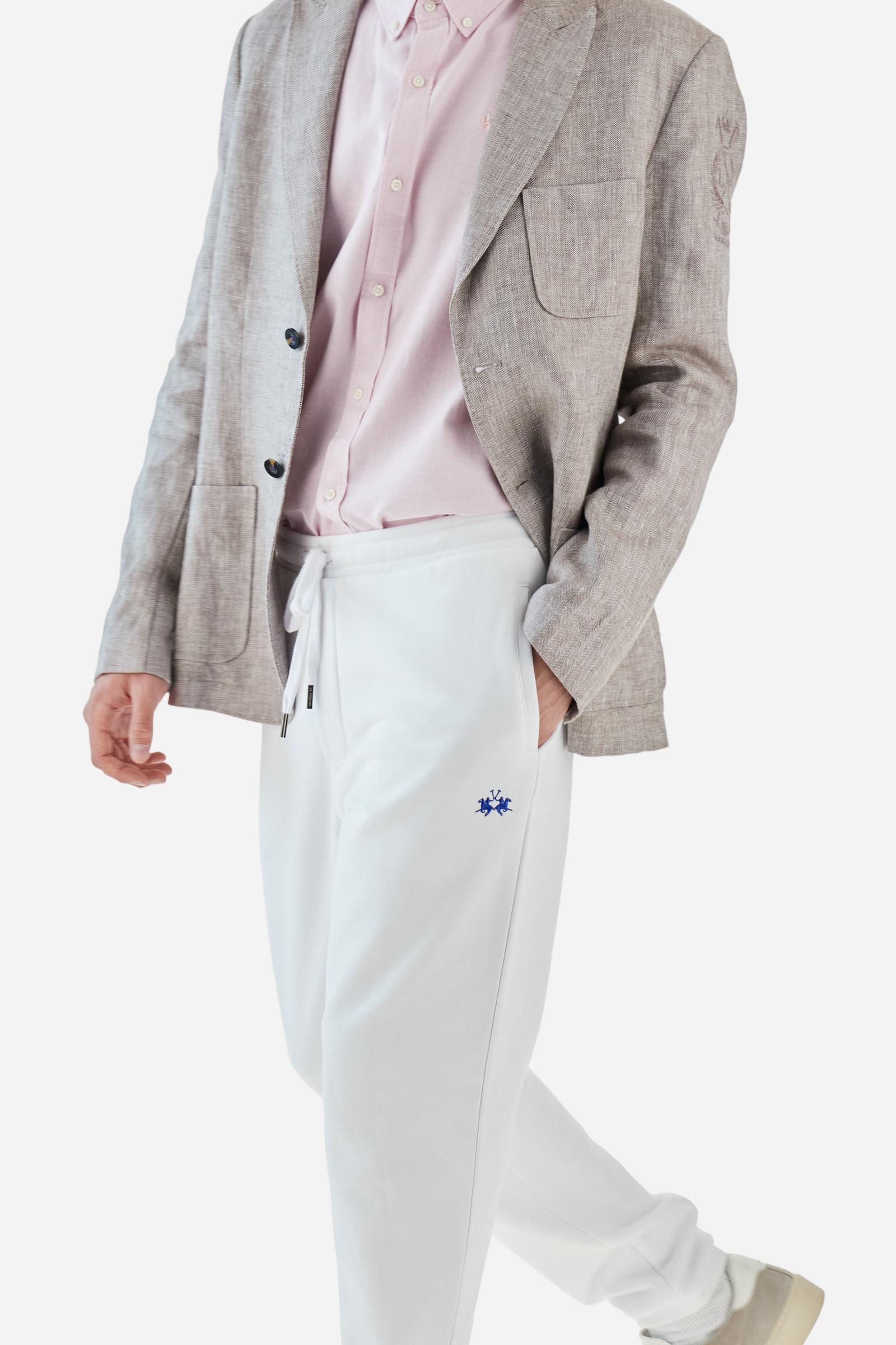 Single-colour men's jogging trousers in a French terry cotton sweat fabric. Removable and adjustable waistband with drawstring. American pockets at the sides. An additional patch pocket is applied on the back. The logo is embroidered in a colour-contrasting thread on the front, left side. The fit is regular. The model is wearing a size L. - Optic White