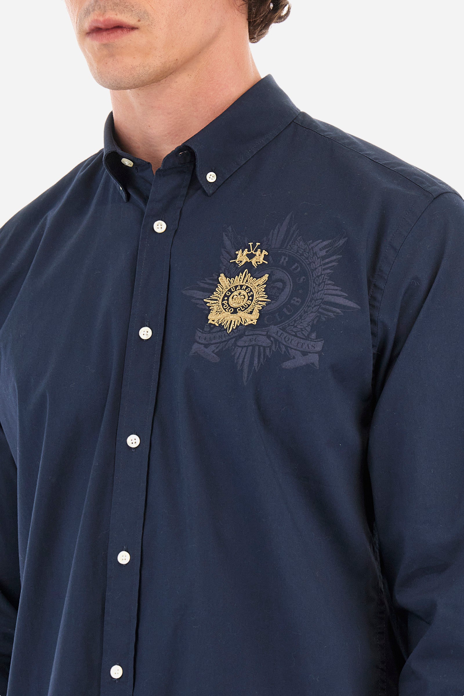 Men's single-colour long-sleeved shirt in elasticated cotton. Button-down collar. With buttoned cuffs. A small logo and the Guards line symbol are embroidered on the front. The fit is regular. The model wears a size L. - Navy
