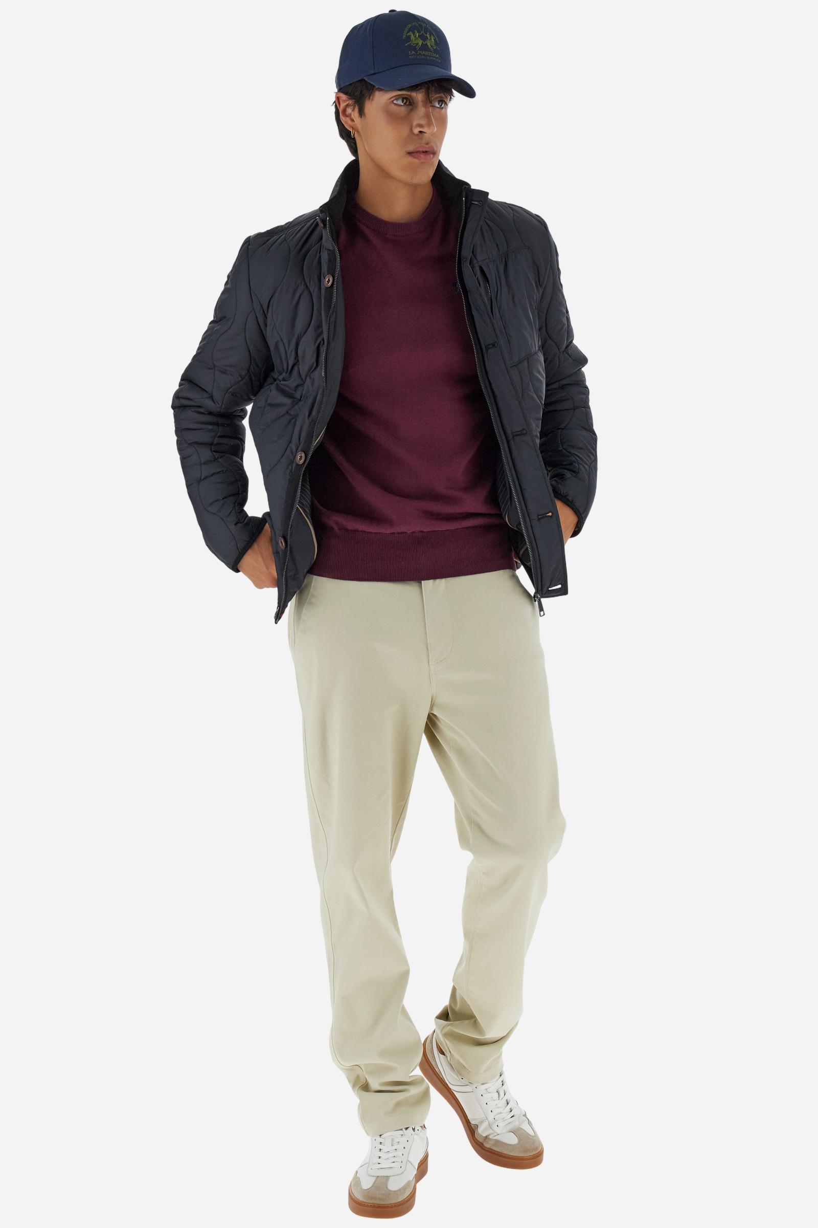 Men’s quilted nylon husky jacket with high collar. Front closure with customized zip and large faux-leather buttons. Interior lined with striped bicolor polyester. Contrast details on the inside (pockets, profiles, back-neck tab). Clean design with chest pocket closed by zip and vertical side pockets. Adjustable back straps with metal snap buttons. Logo patches on the sleeves and multicolor embroidered lettering on the outer collar. Part of the Guards capsule. Regular fit. Model wears size L. - Black