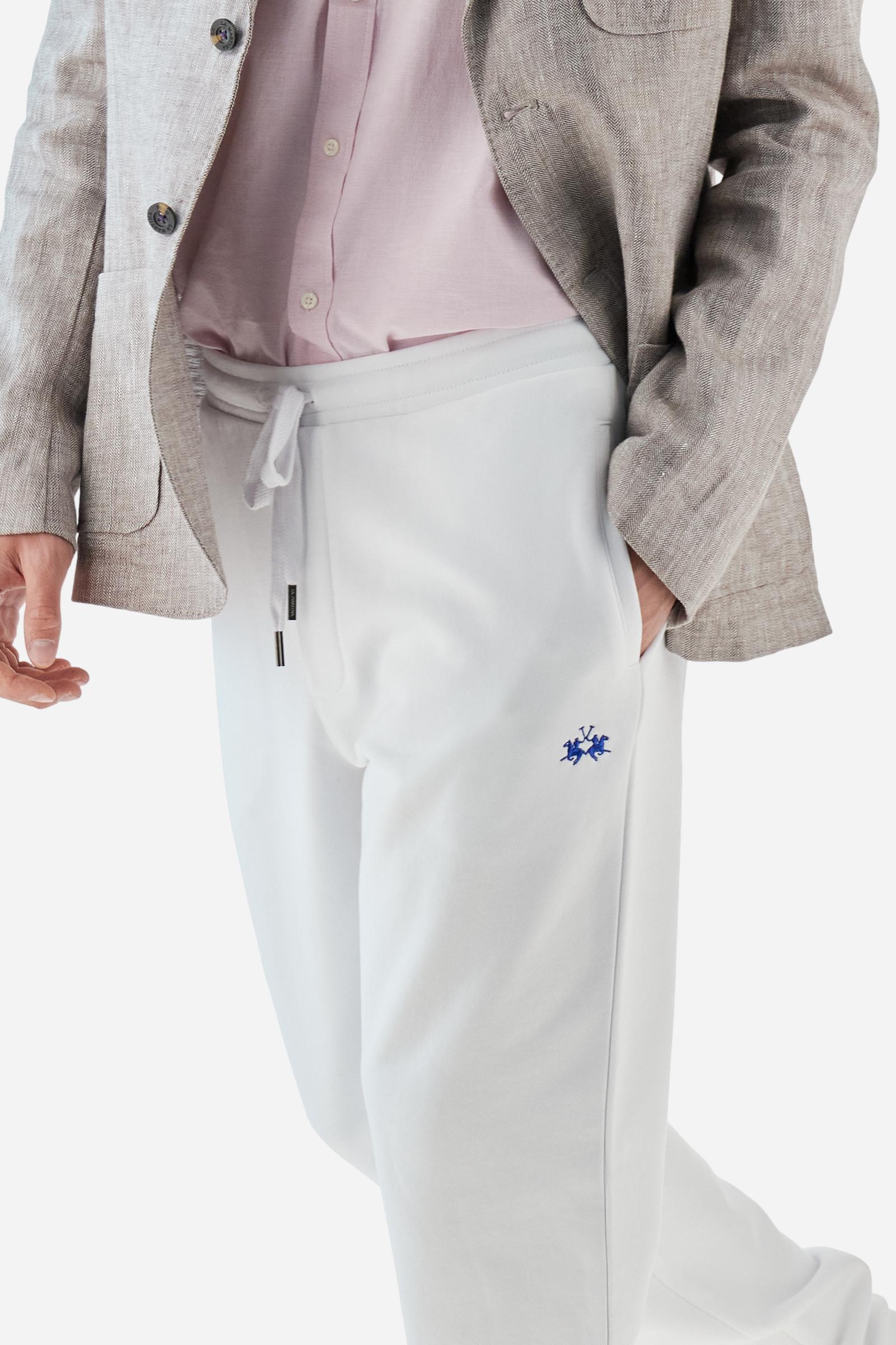 Single-colour men's jogging trousers in a French terry cotton sweat fabric. Removable and adjustable waistband with drawstring. American pockets at the sides. An additional patch pocket is applied on the back. The logo is embroidered in a colour-contrasting thread on the front, left side. The fit is regular. The model is wearing a size L. - Optic White